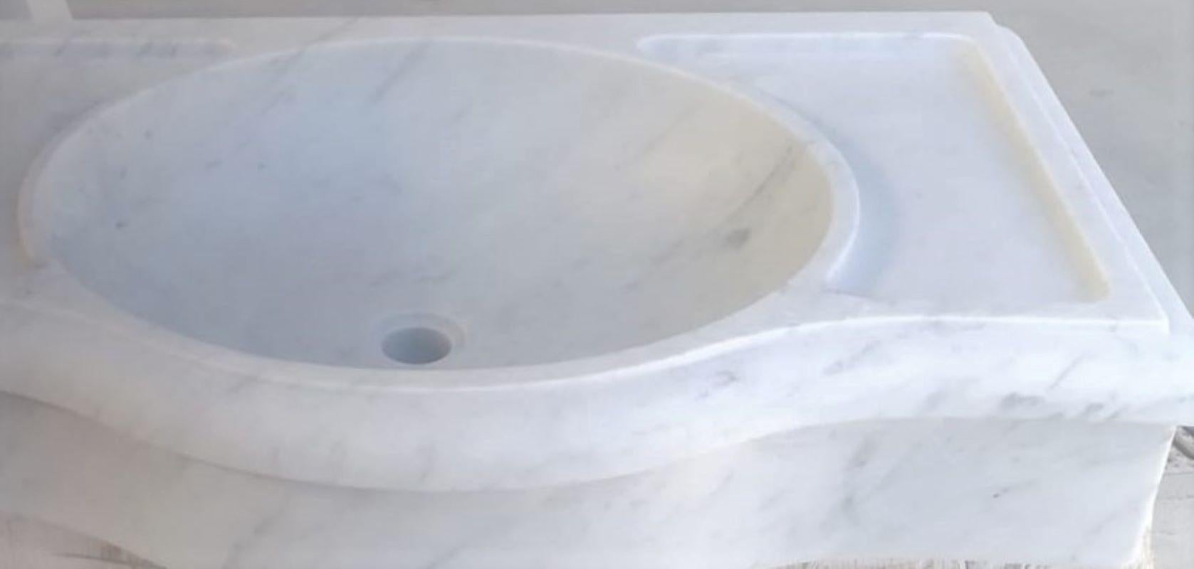 Dieses zeitlos schöne, klassische italienische Waschbecken wird aus einem einzigen Block weißen Marmors geschnitten, dessen Design sich seit der griechischen und römischen Zeit nicht mehr verändert hat und das sich hervorragend in alte und neue