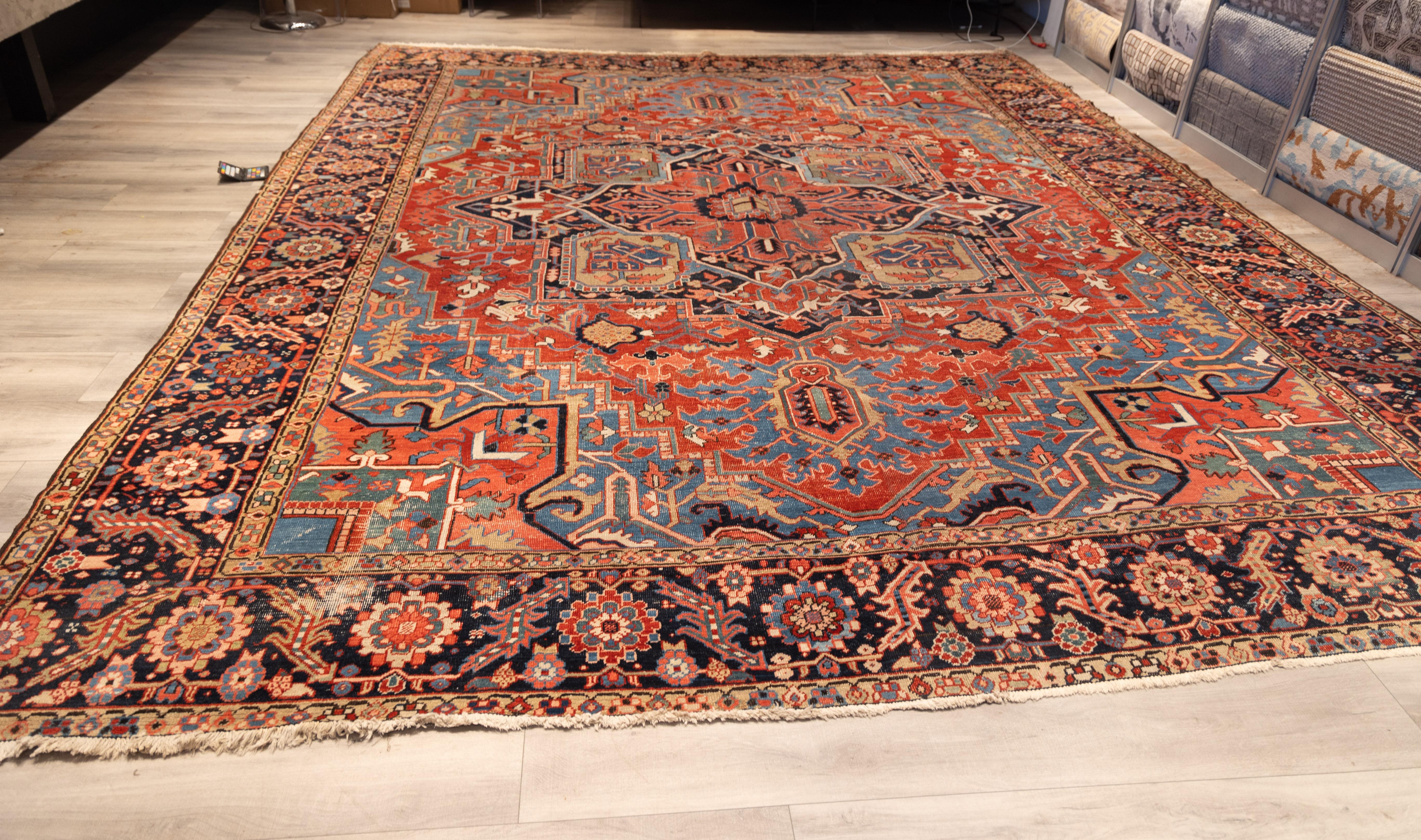 Stunning 20th-century Heriz rug With a medallion design in a saturated palette of brick red, midnight blue, and sky blue. The robust central medallion radiates geometric intricacy, flanked by  corner spandrels with angular, serrated leaf motifs and