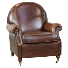 Classical, dark sheep leather armchair in good condition and on wheels