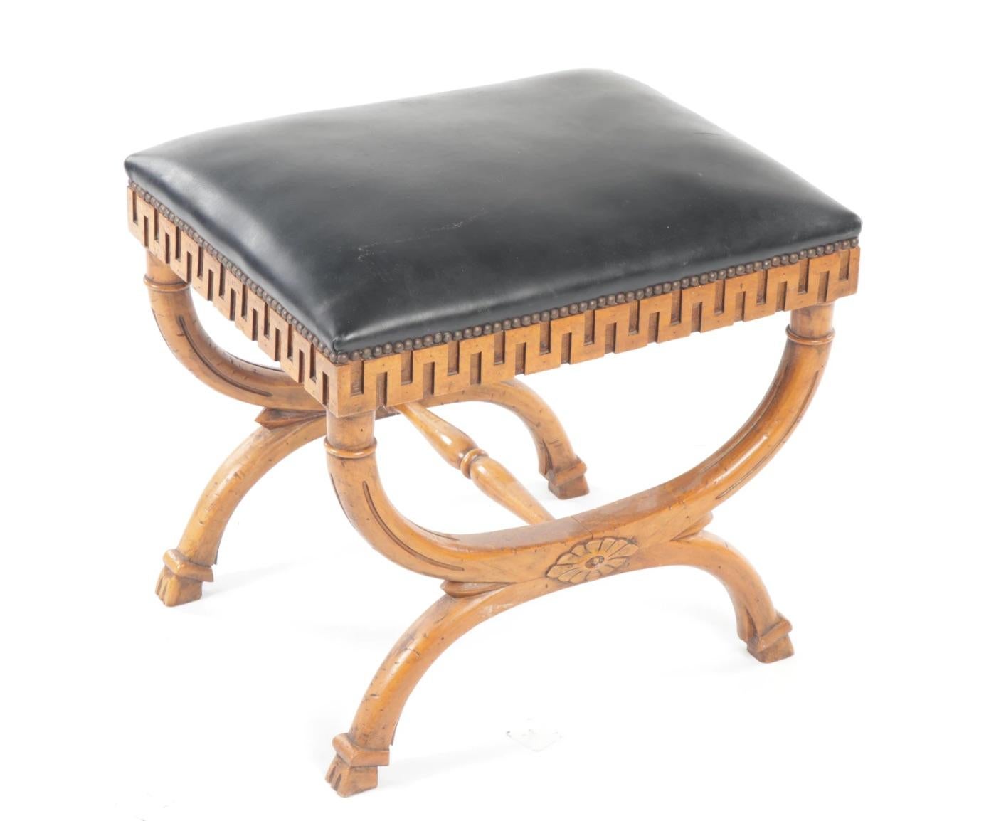 Very distinctive Greek classical style fruitwood stool bench, having a crown seat, with nailhead trim, apron carved with Greek key style Meander, on curved, X-form legs, centered by a rosette, joined by a turned stretcher with hoof foot. Nicely aged