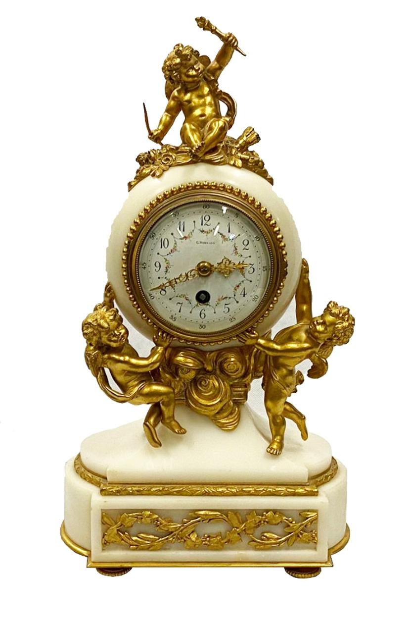 An enchanting 19th century Louis XVI style clock garniture, having gilded ormolu mounts with three cherubs with ribbon swags, the white enamel clock face with an eight day chiming movement and raised on a plinth base. Either side are matching