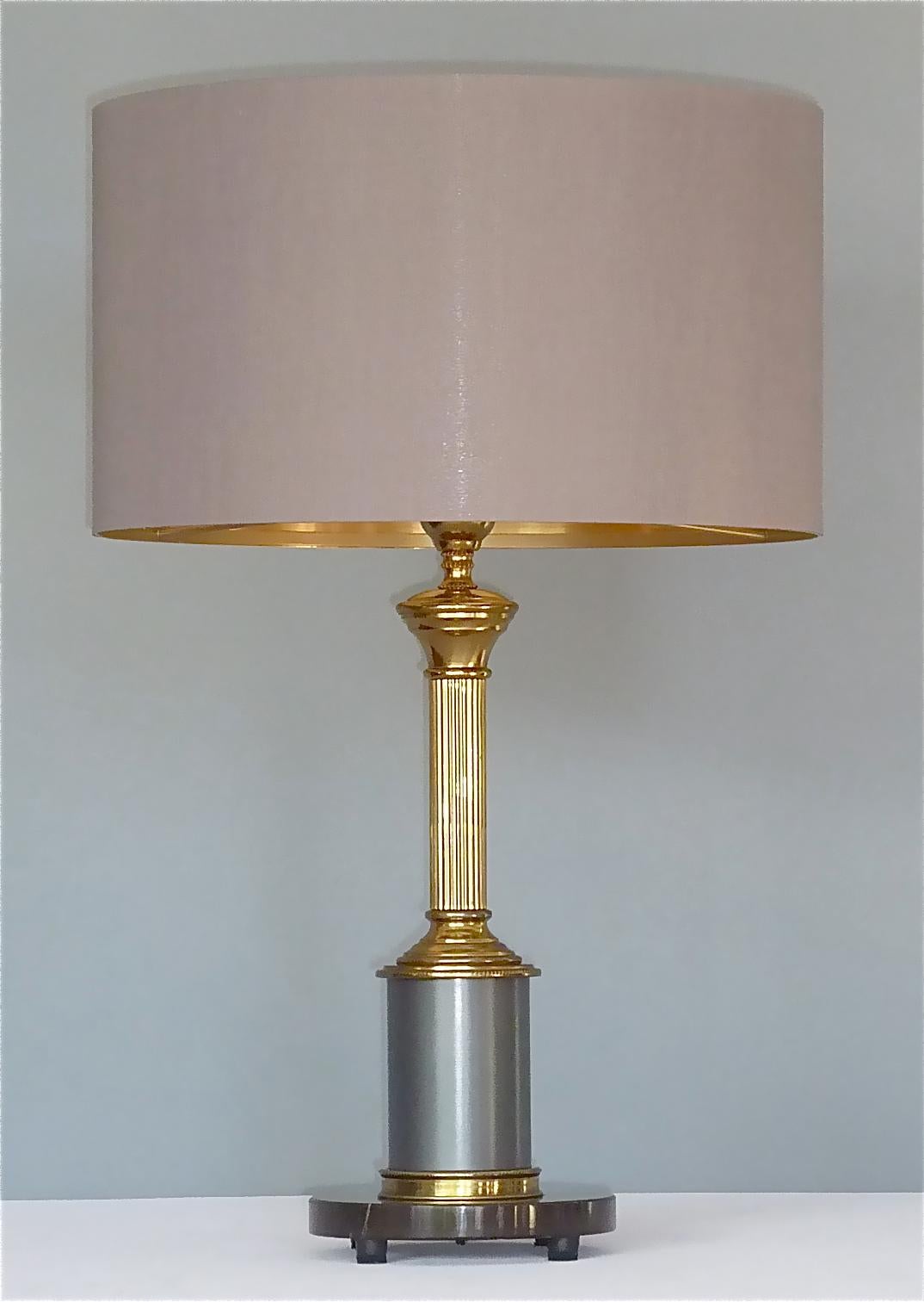 Rare et magnifique lampe de table classique du milieu du siècle dernier, conçue et exécutée par la Maison Jansen, France, entre 1940 et 1950. La lampe de table a un disque de marbre gris à noir comme base avec une colonne en laiton émaillé et patiné