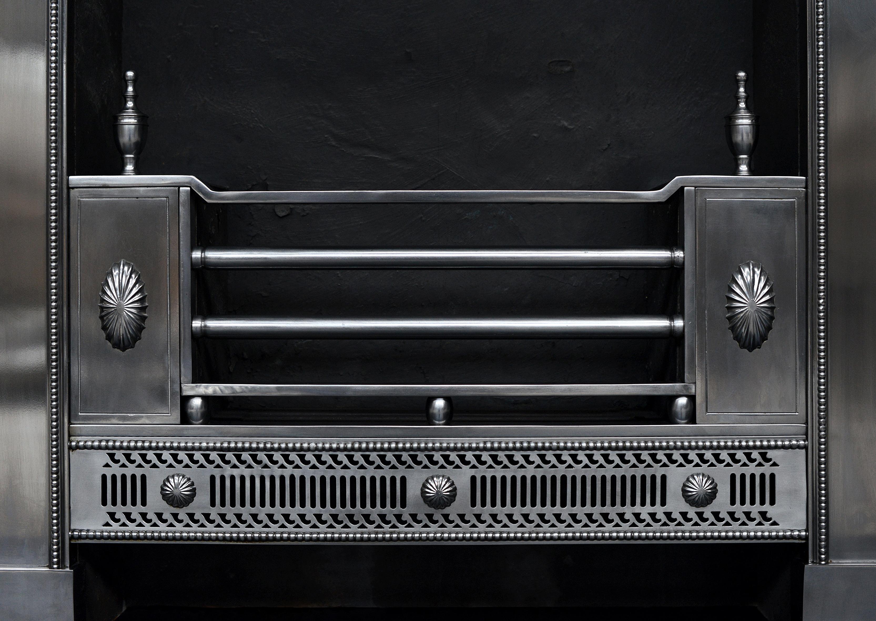 A fine quality George III steel register grate. The pierced, fluted fret with double scrolls and beaded molding and gadrooned pateras. The front panels with oval paterae, surmounted by urn finials. The frame with matching patera to centre juxtaposed