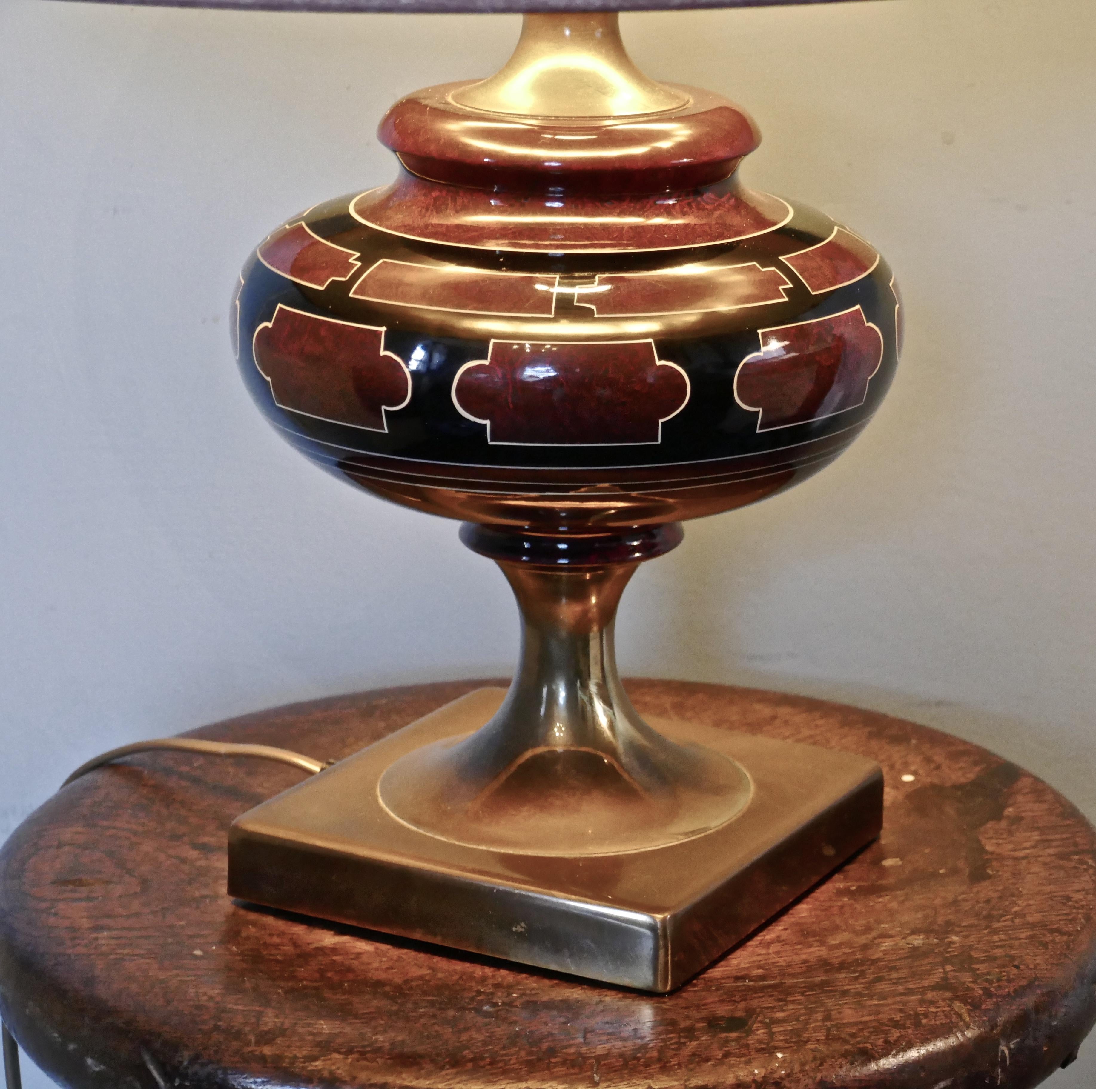 Classical Grecian look Art Deco ceramic table lamp.

The lamp stands on a brass foot and has a ceramic bowl which is decorated as simulated marble with a Classical Greek design decoration.

The lamp is black and wine coloured and has a matching