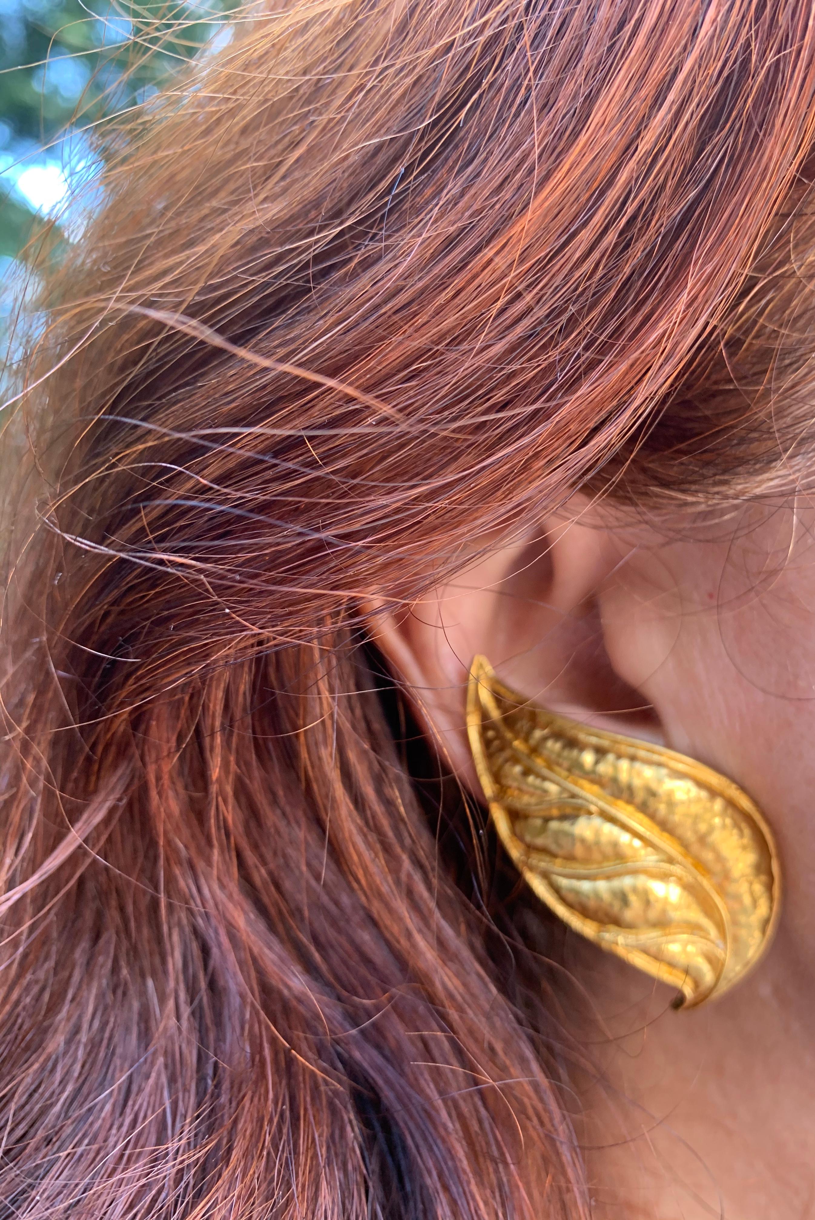 Very large, striking Archaeological Revival style 18k heavy hand hammered yellow gold Laurel Leaf earrings. Beautifully crafted with artful attention to detail and designed to be worn to complement the curved line of the ear. Classically glamourous