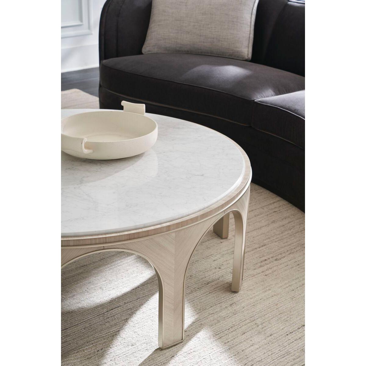 Much like the cultural center of ancient cities, the table grounds the room and invites guests to gather. With details inspired by classical architecture in Rome, it features a white marble top and Koto veneer-wrapped arches in a pearlescent