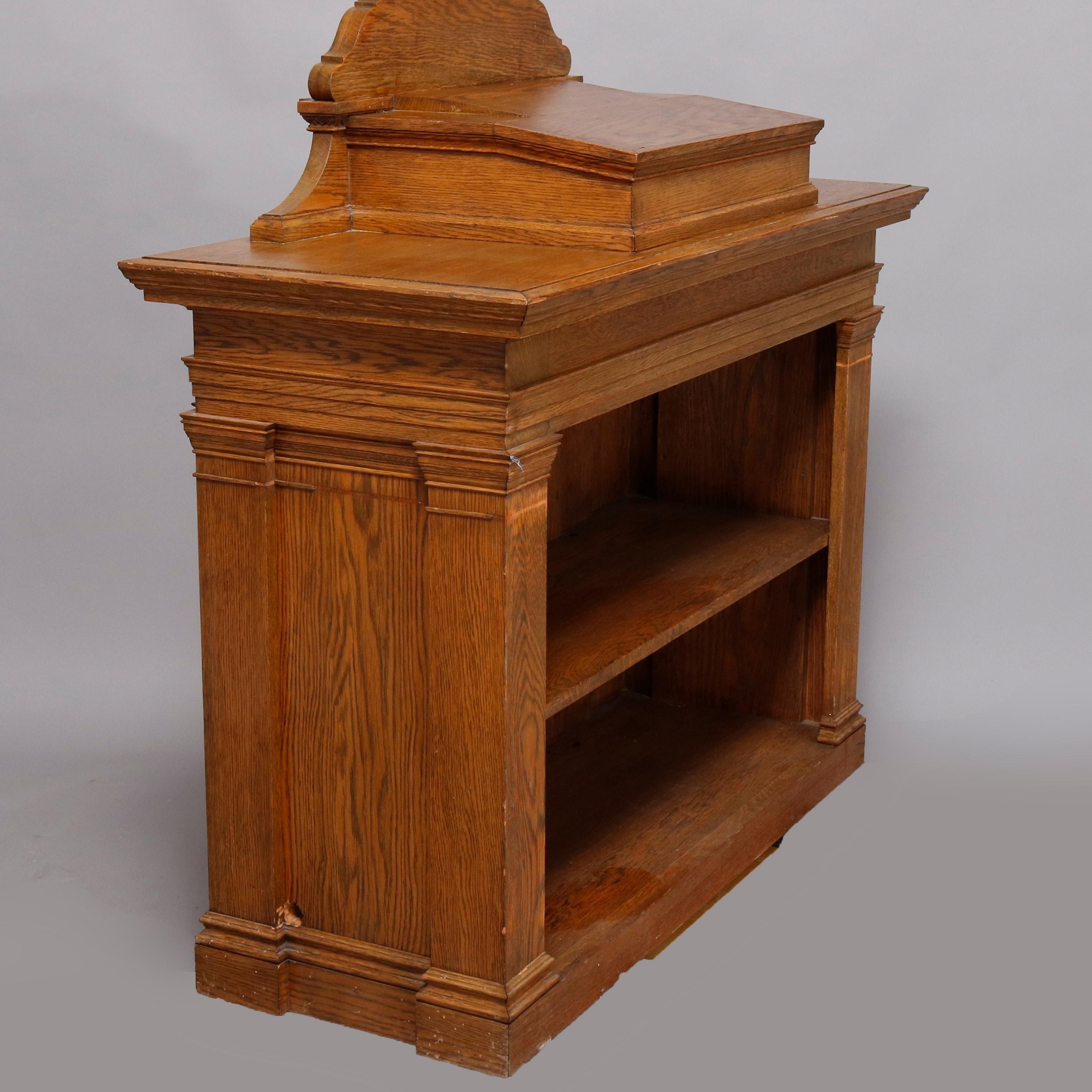 A vintage oak presentation podium or academic lectern offers oak construction with front panel having Greek key bordering and flanked with carved Corinthian columns, interior with shelving, 20th century
classical oak podium, 

***DELIVERY NOTICE –