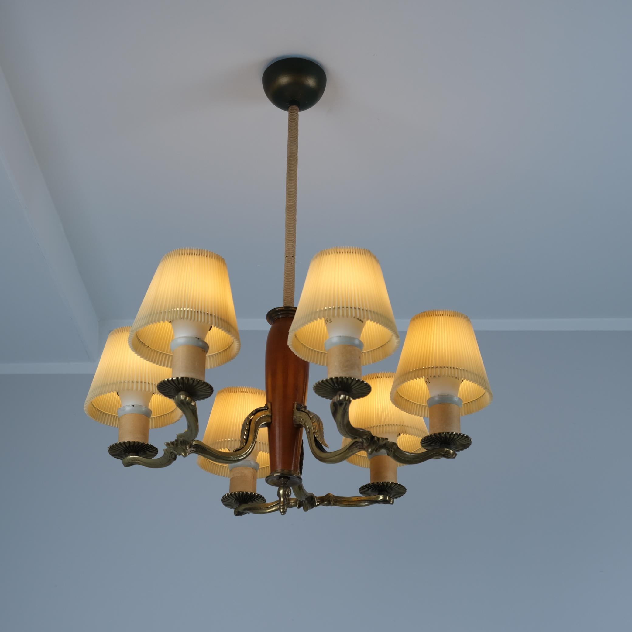 Ein schönes Beispiel für die klassischen Lampen von Paavo Tynell aus den 1930er Jahren. Das Modell 1355 ist aus dunkel gebeiztem Birkenholz gefertigt und verfügt über drei patinierte Messinggussarme, die sich in zwei kerzenförmige Spitzen aufteilen,