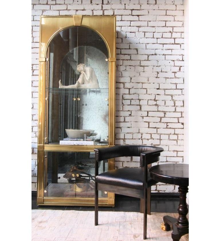 An impressive vitrine in the classical Palladian style, manufactured by Mastercraft, circa 1970s. With two-door arched fronts, antiqued smoked mirror back, clear glass against brass frames. The interior with three glass shelves above lower two-door