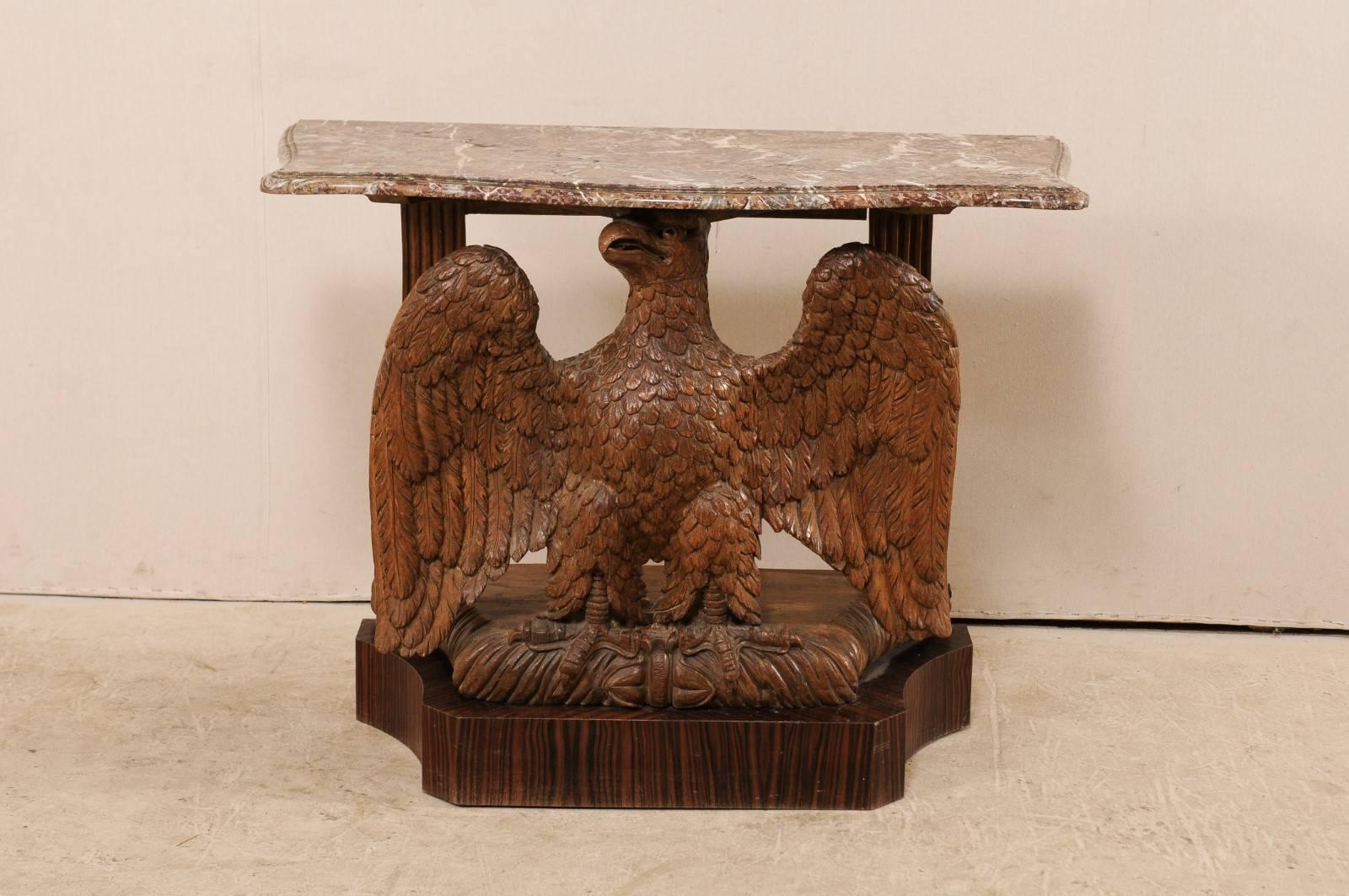 A classical period American marble-top console table with carved eagle base, circa 1820. This antique American table features a hand carved wood eagle with exquisite details, mounted atop a Macassar ebony base, which is a later addition to the