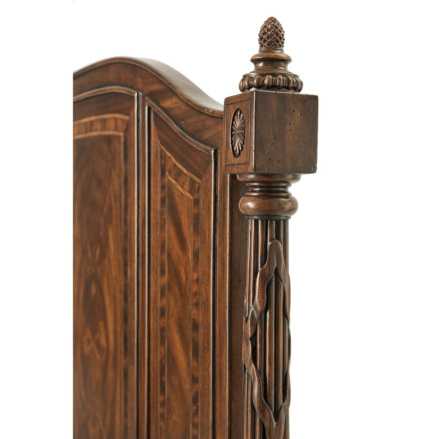 A Classical polished veneered and crossbanded King size bed, the arched headboard of three crossbanded panels flanked by bound reeded carved columns, with a paneled low footboard, on turned tapering legs. Inspired by a 19th-century French