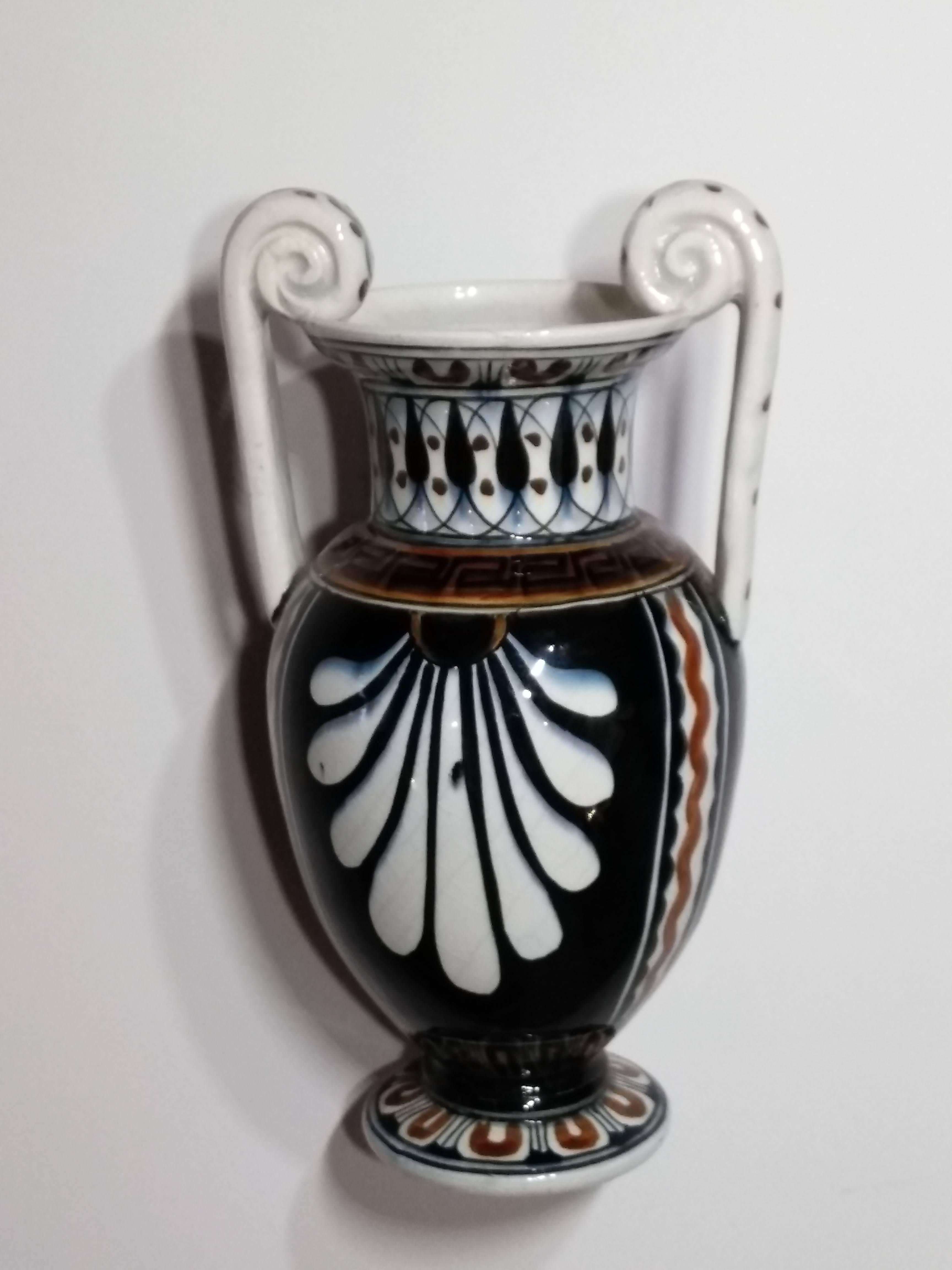 Beautiful classical porcelain vase with Greek key accent design. This case features a man and woman looking at each other. The vase has two curved decorative handles and hand-painted details all around. 

Marked on the bottom.
 