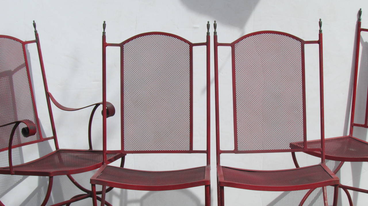 Vier schmiedeeiserne Stühle mit Metallgeflecht in Curule-Form im klassischen Stil (drei Beistellstühle und ein Sessel) mit Messing-Urnen an den oberen Pfosten in insgesamt schön gealterter Originaloberfläche. Schauen Sie sich alle Bilder und lesen