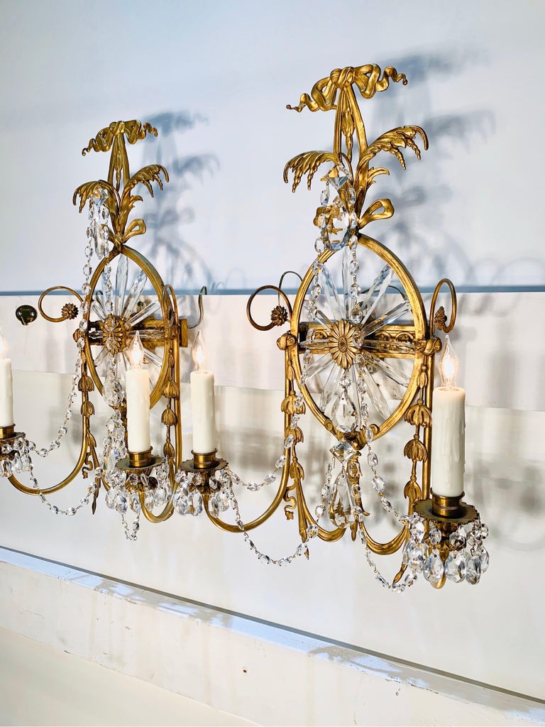 Grand pair of Caldwell scones with elegant crystal sunburst and fine bronze neoclassical frame. This pair of sconces has two candle arms and are in the Robert Adam style.