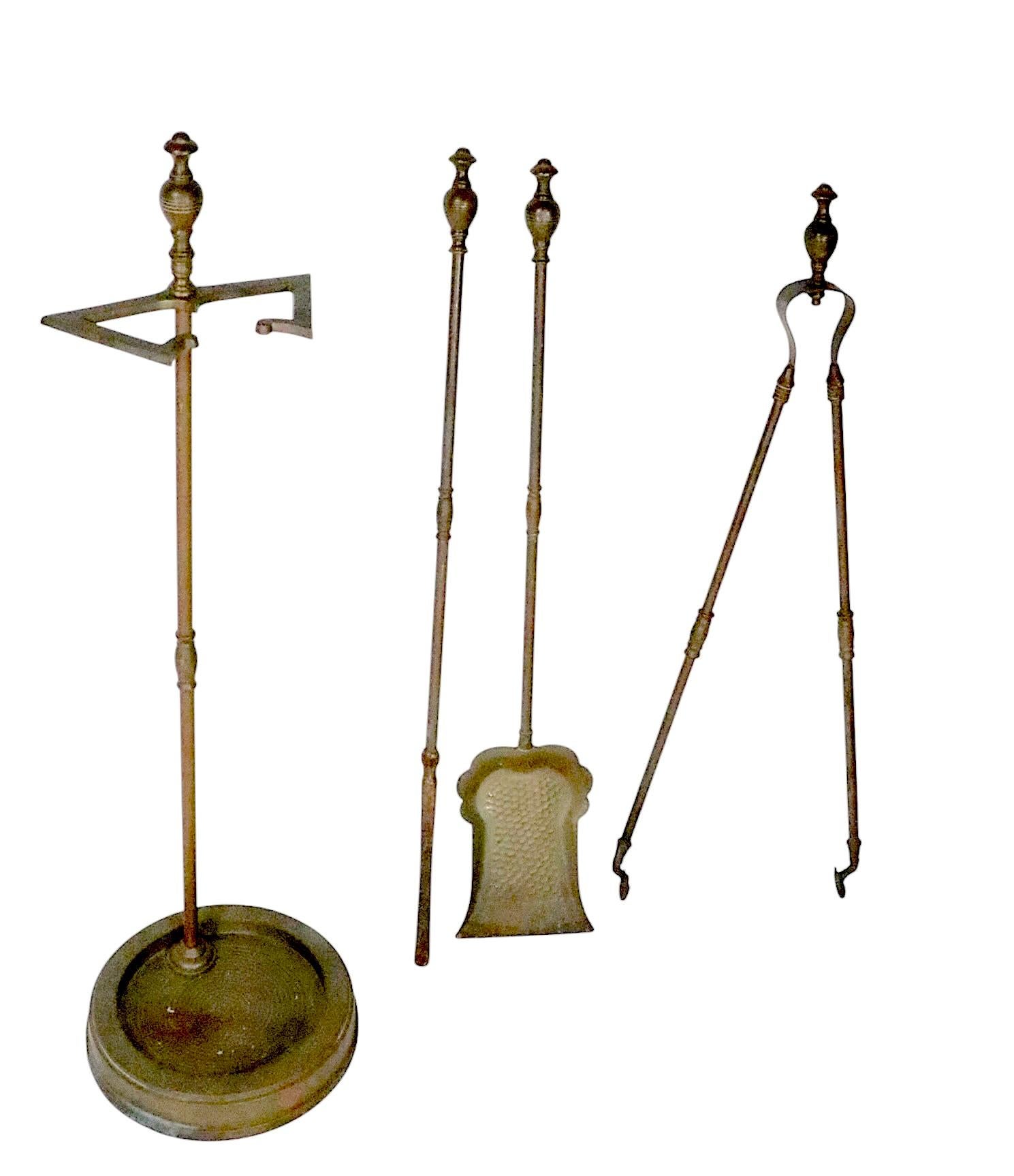 Exceptional antique brass fireplace tool set to include a shovel, tongs, poker and the stand. Executed in the Aesthetic Movement style, made in the late 19th or early 20th century, after Christopher Dresser, unsigned. 
 Very good, original, clean