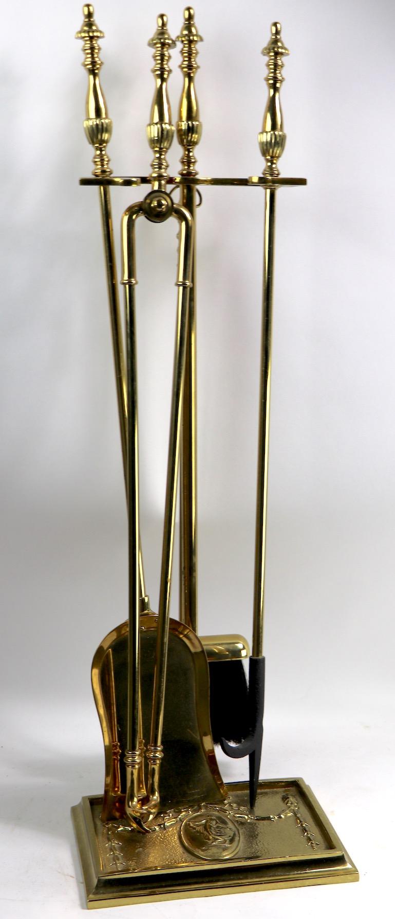 Decorative classical style brass fire tool set to include stand, poker, brush, shovel and tongs. The stand has a woman in flowing gown cast in relief. Original, clean and ready to use.