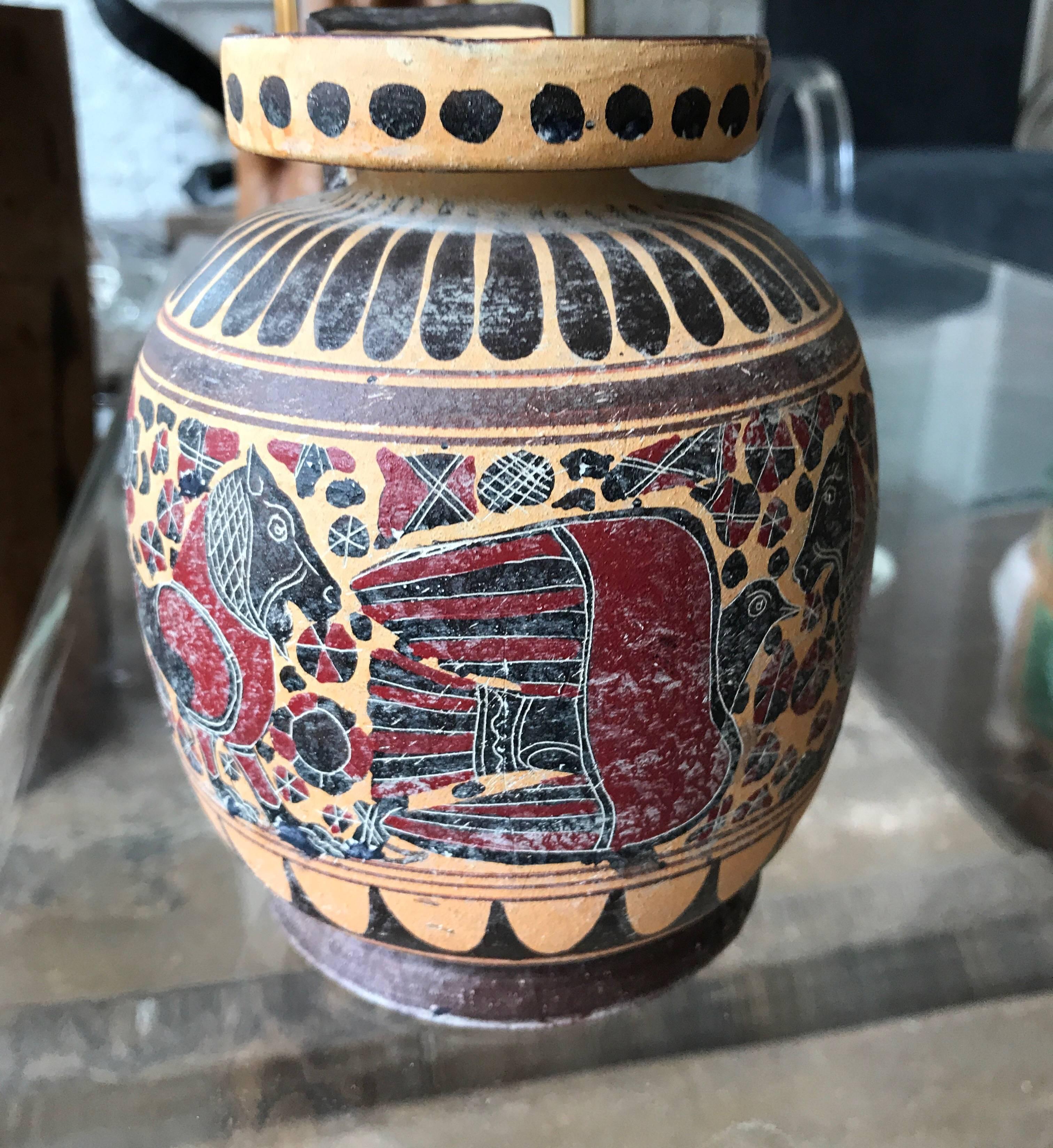 A classical style ceramic Greek vase in the ancient style. The vase is decorated with images of
animals. Beautiful tabletop decorative object. Signed on the bottom by the artist D. Sarakatsianoo.