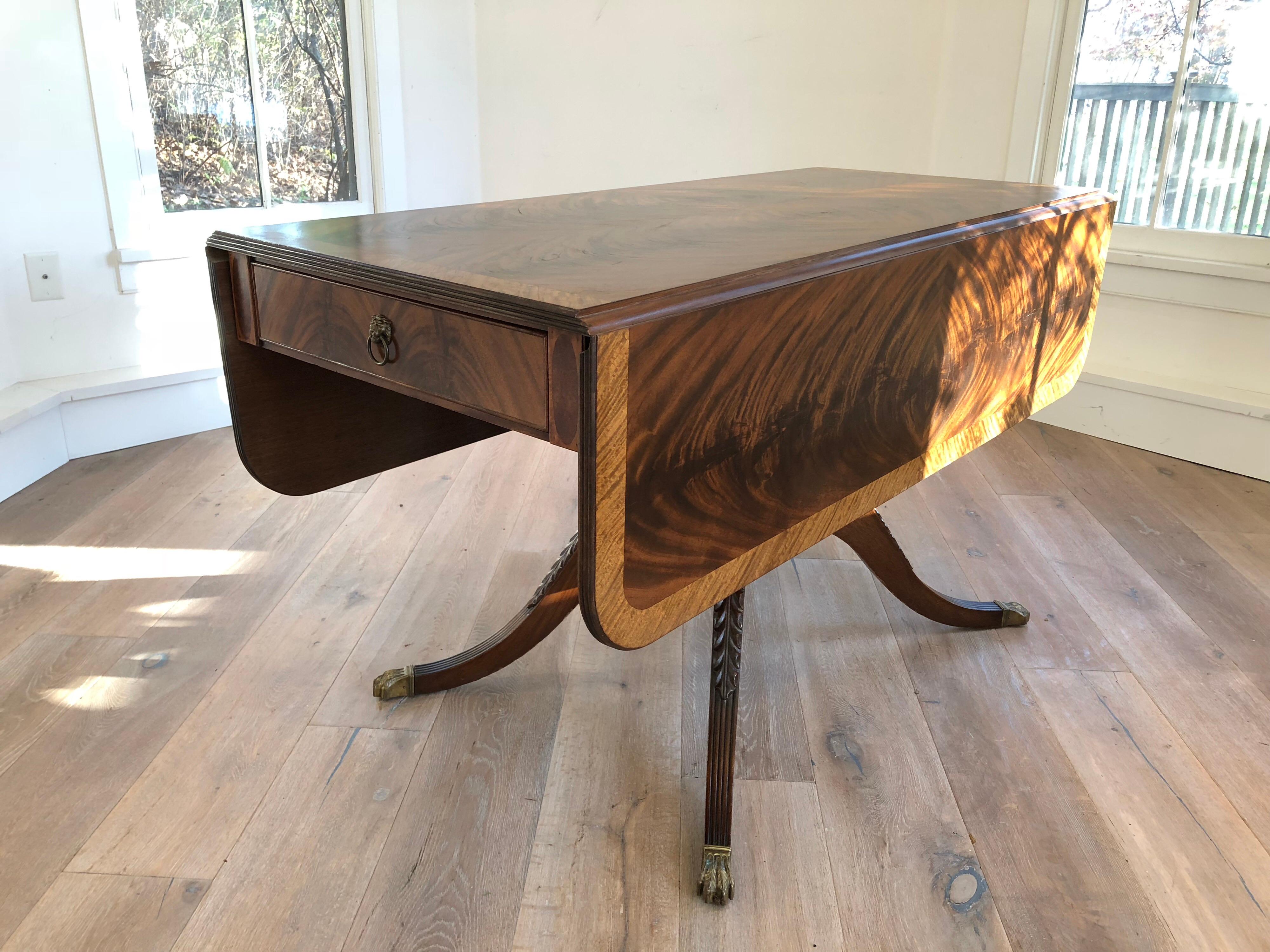 A Classical style drop-leaf library table. Beautiful flame stitch mahogany top and two drawers on either end. Brass pull hardware and feet caps. 
Top measures 54