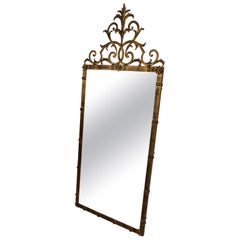 Miroir en métal doré de style classique avec décoration de rosettes sur le dessus en forme de fleuron à volutes