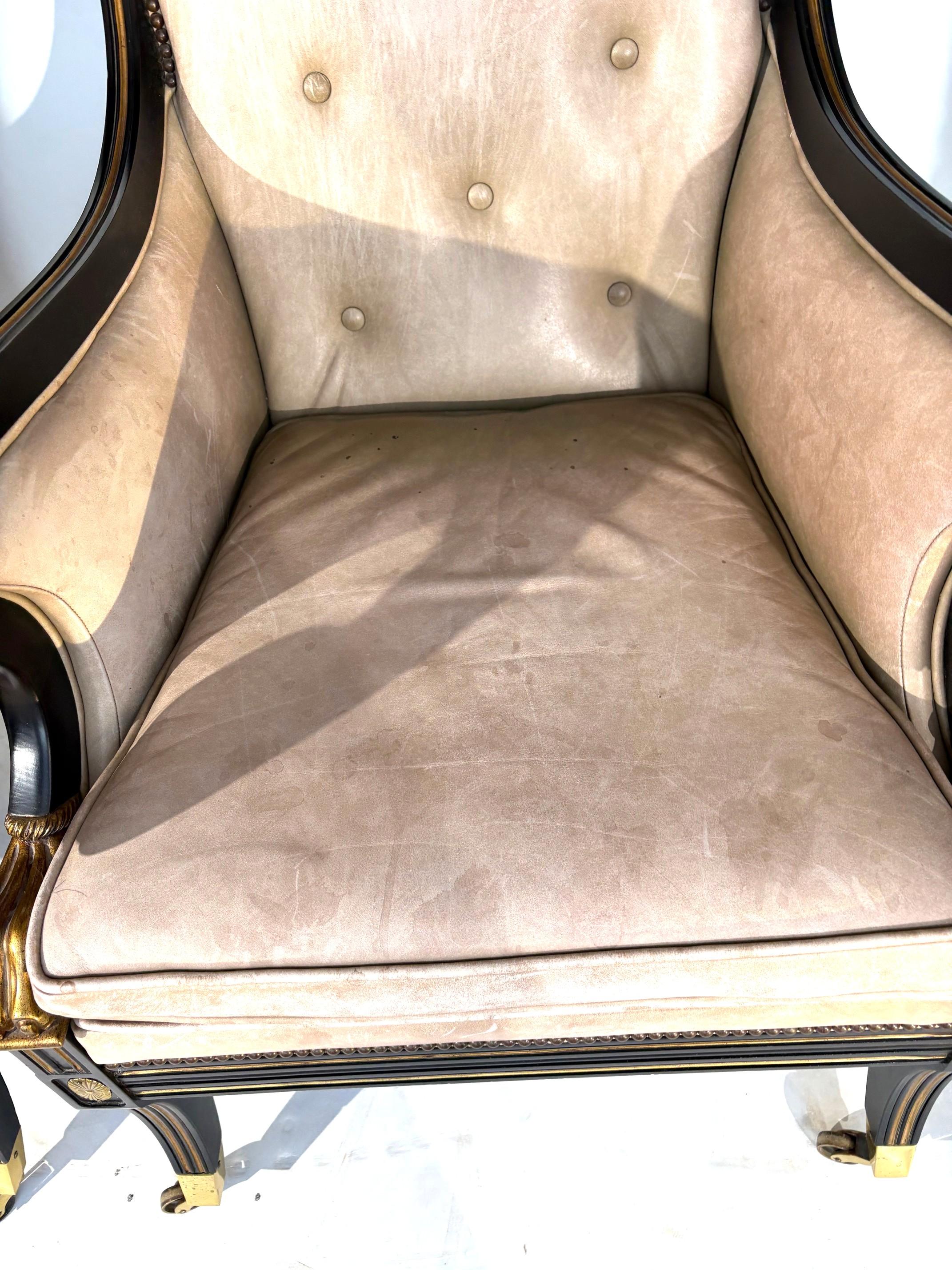 

Paire de fauteuils vintage de style néo-classique de qualité supérieure, fabriqués par Baker Furniture. Finition ébénisterie avec rayures dorées. Accoudoirs à volutes avec supports en patte de lion dorés. Décorations en médaillon sur la partie