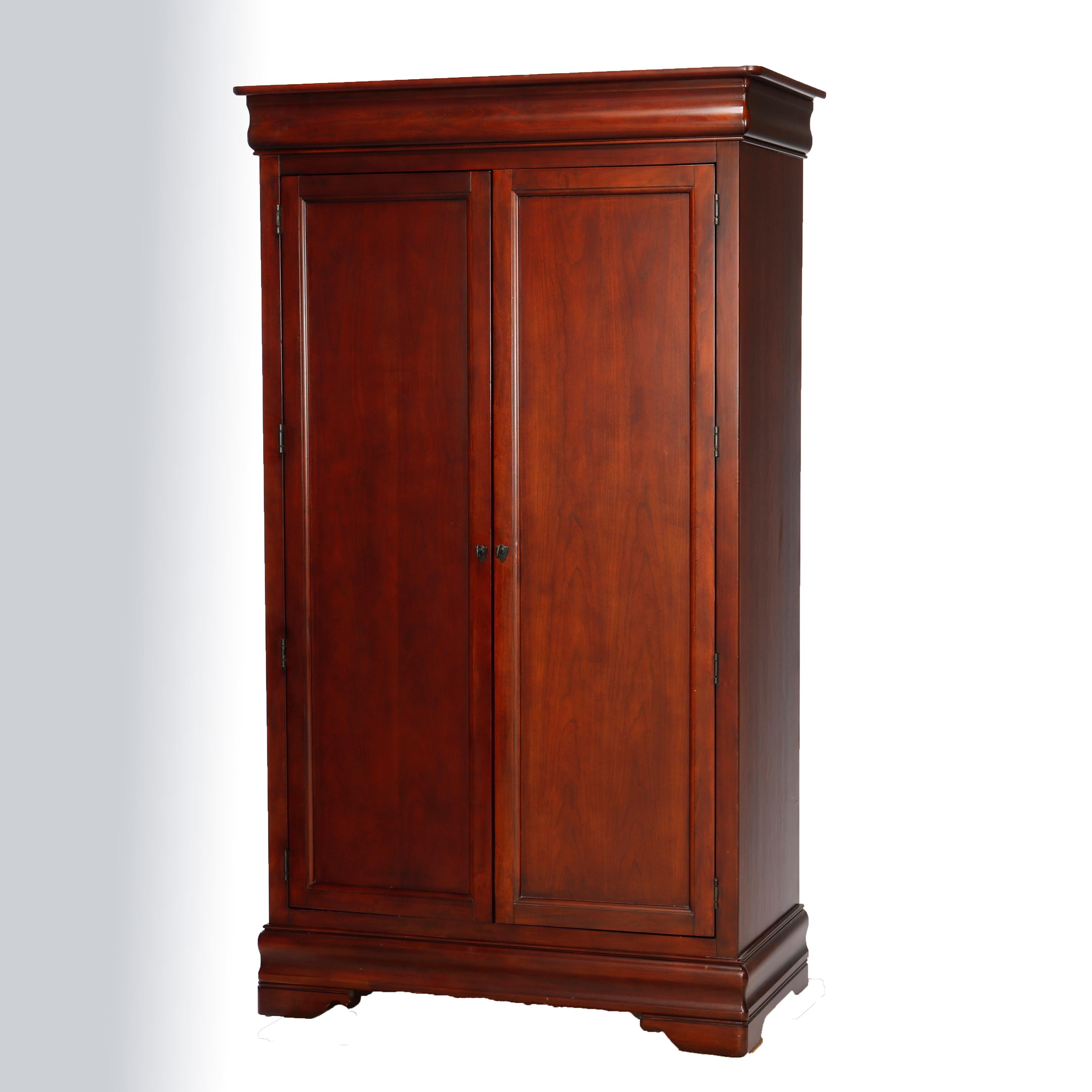A Classical style entertainment center by Broyhill offers mahogany construction with double paneled doors opening to interior having three long drawers, having ogee molding and raised on bracket feet, maker mark as photographed, 20th