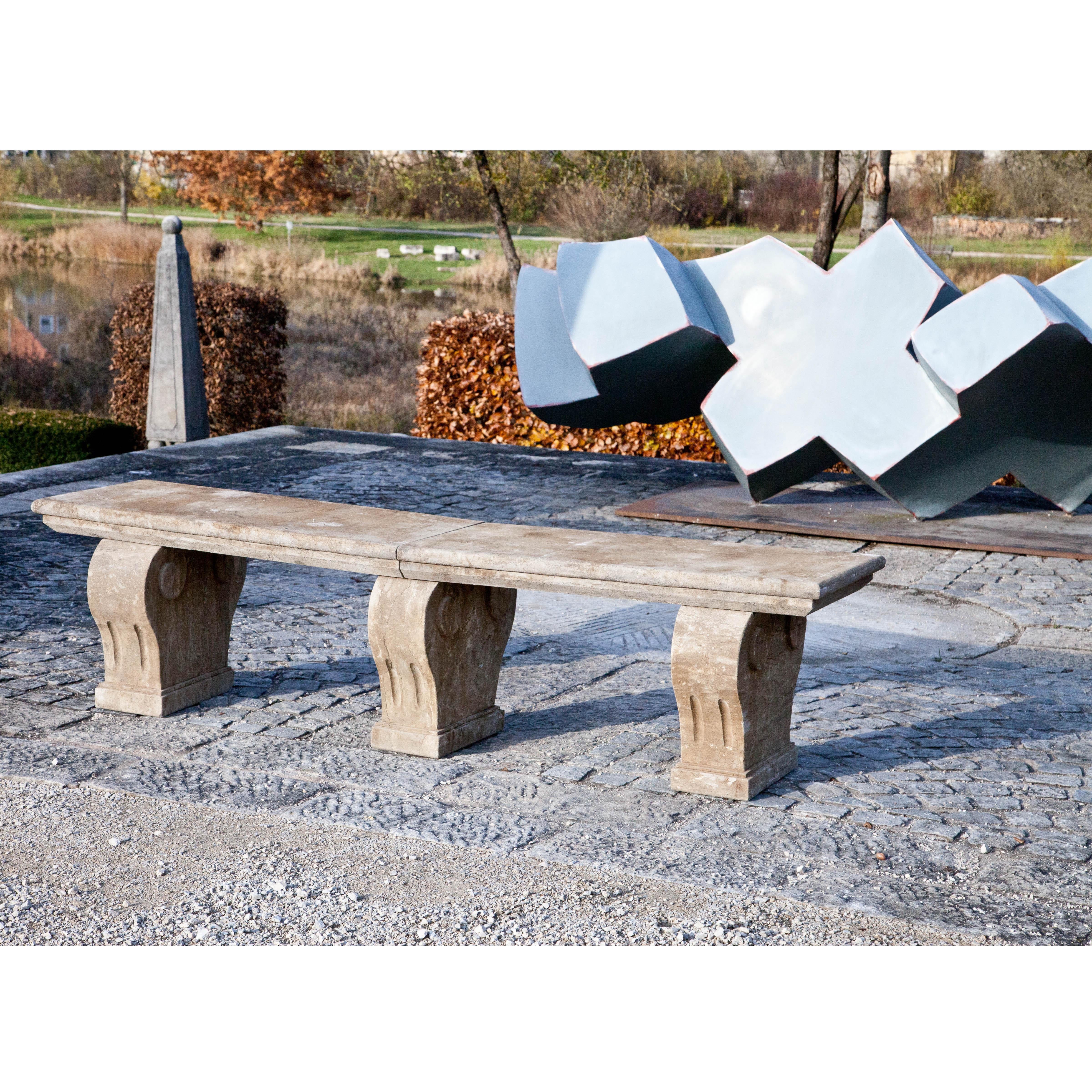 Park bench with rectangular seat on three curved legs, handmade of blue stone.