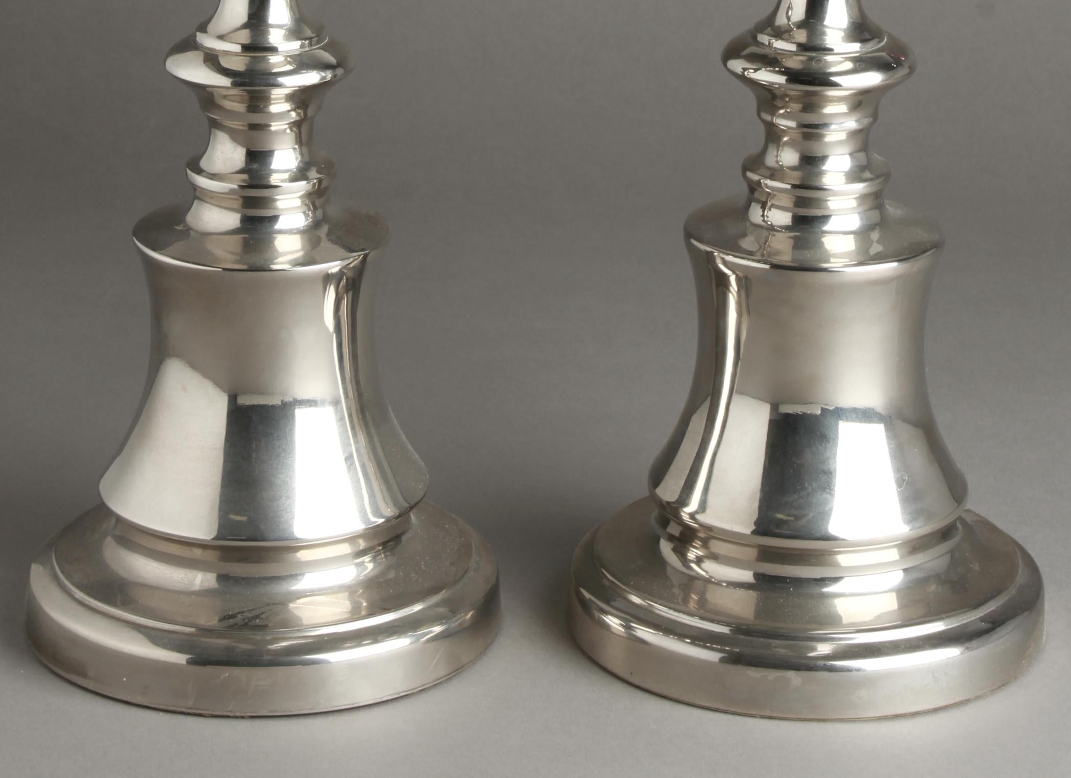 Pair of classical style silver tone candlesticks in cast aluminum. The pair is in great vintage condition with age-appropriate wear.
