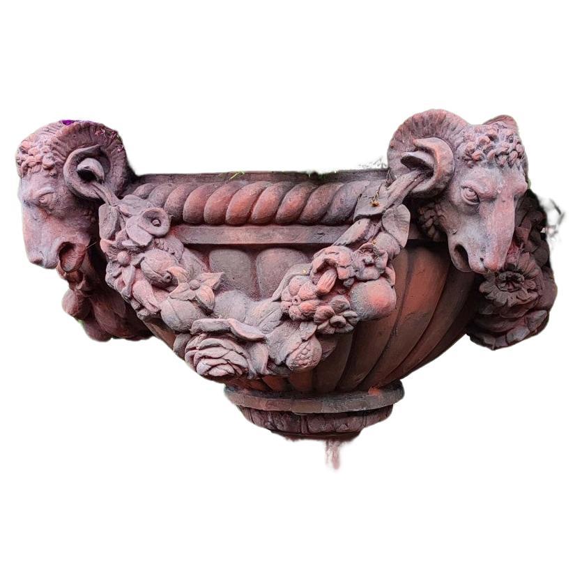 You are viewing a gorgeous English terracotta garden urn in the Regency manner
Great for achieving that classical English garden look
Wide planters features distinctive rams heads to each side
Further complemented by the floral encrusted sash that