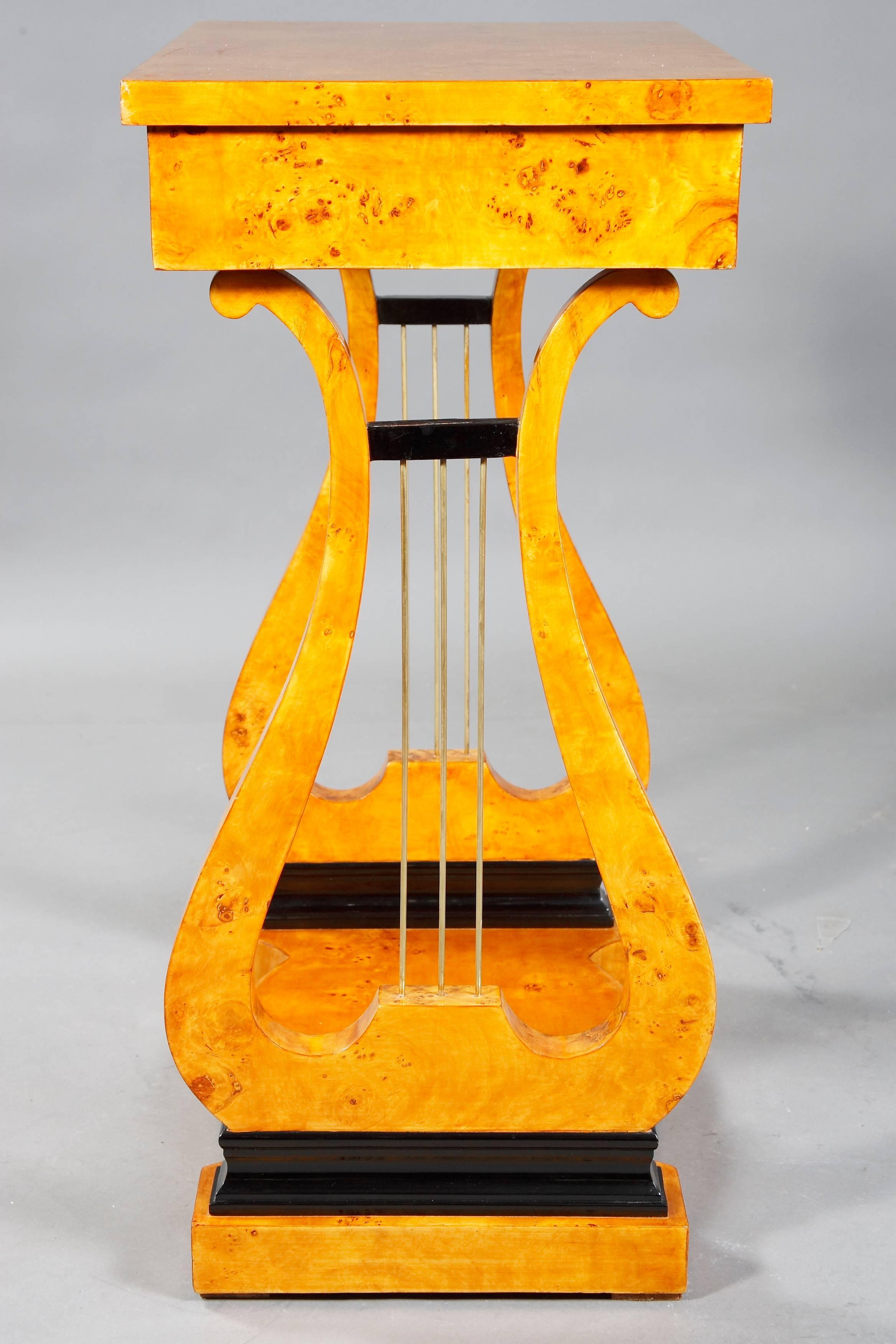 Maple root on solid softwood. Straight, on lyre-shaped, openwork cheeks with metal sides. Seal-shaped base plate. Upper drawer with compartments. protruding rectangular plate. Beautiful patina, with shellac hand polish. Literature reference: Georg