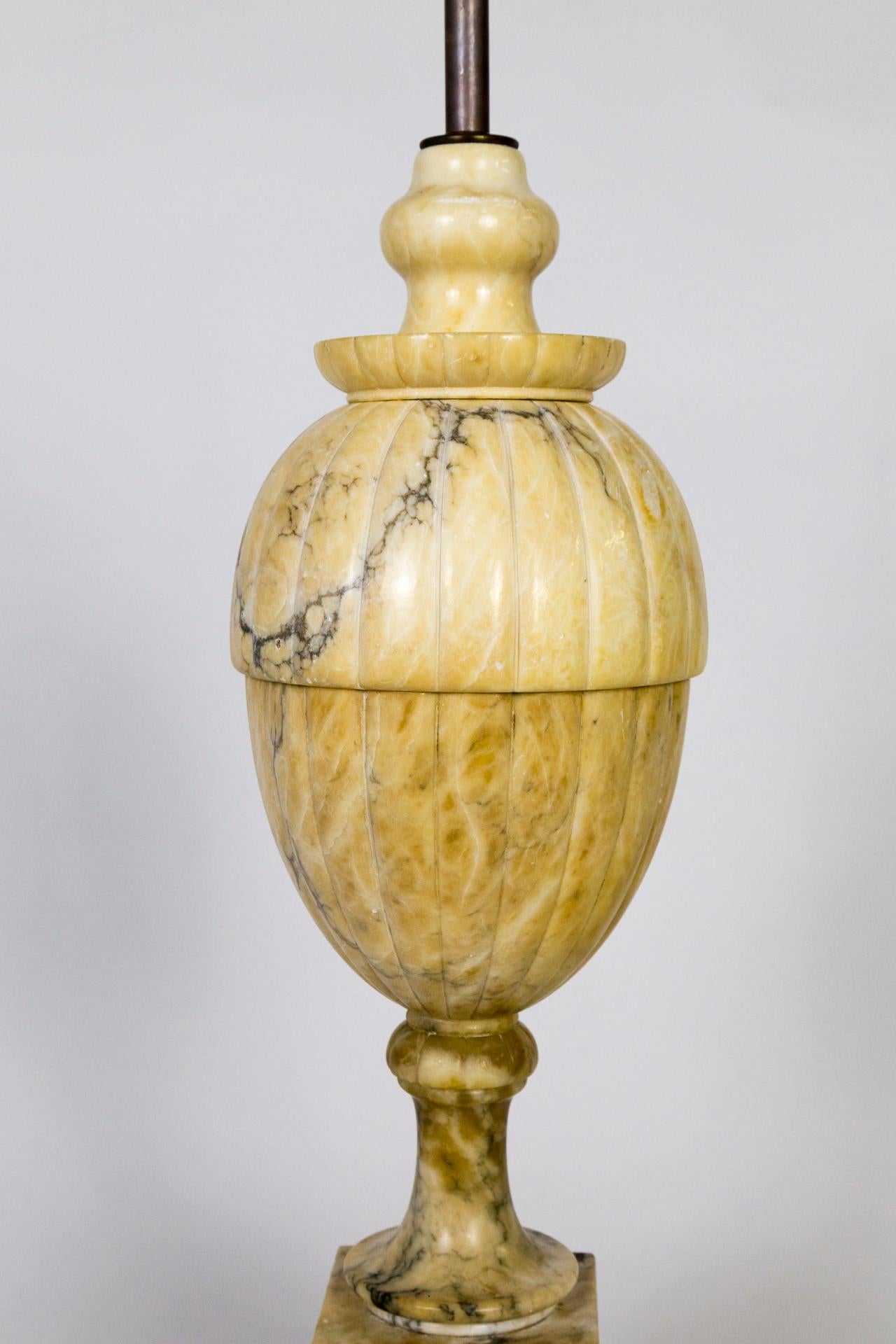 Une lampe urne de grande taille dans un complexe de marbre au grain et à la couleur ambrée. Monté sur une base originale, dorée. Nouvellement rebranché avec un col en laiton et une douille teintée en bronze, américain, années 1930. Mesure : 8