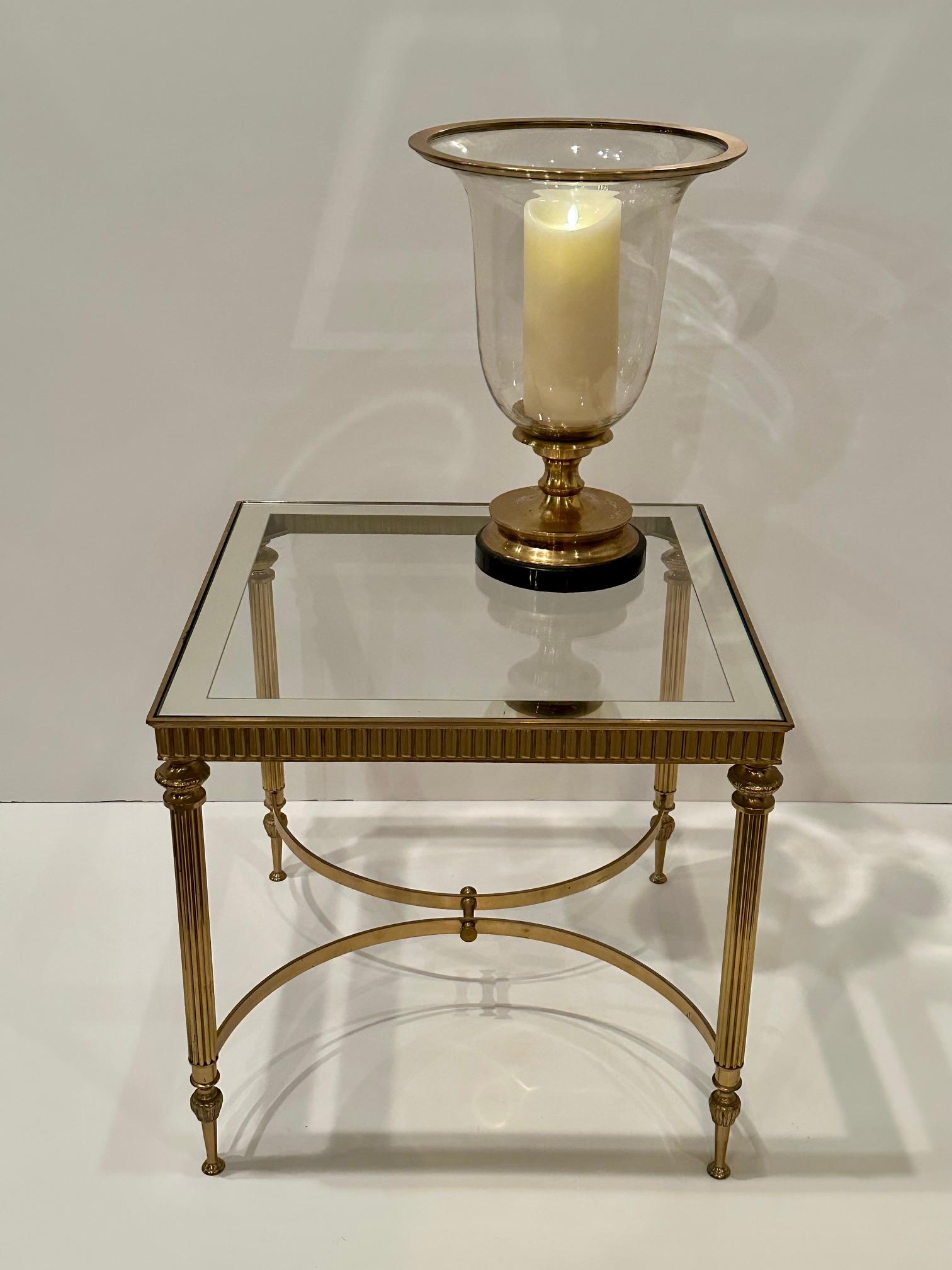 Klassisch eleganter französischer Beistelltisch im Maison Jansen-Stil mit Messingfuß und Glasplatte, die mit einem silbernen Band eingefasst ist.