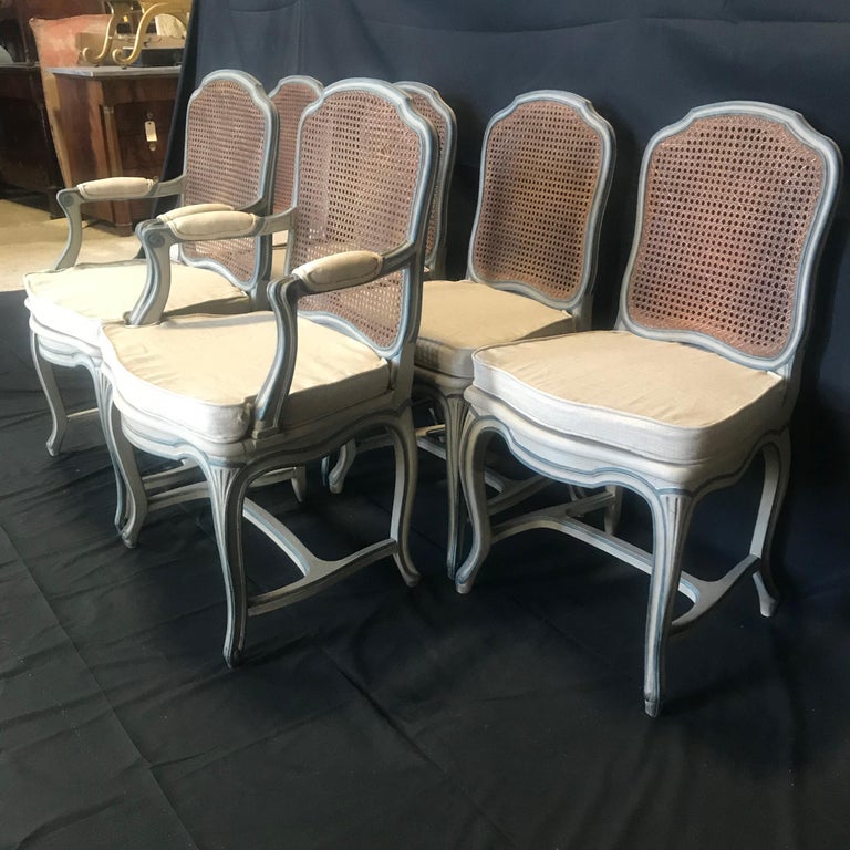 Set of six 19th century French chairs with new upholstered seat and arm cushions in blue gray paint. Sinuous lines in the French Provincial tradition. Matte paint in typical French blue gray. New custom cushions have been made to fit these chairs. A