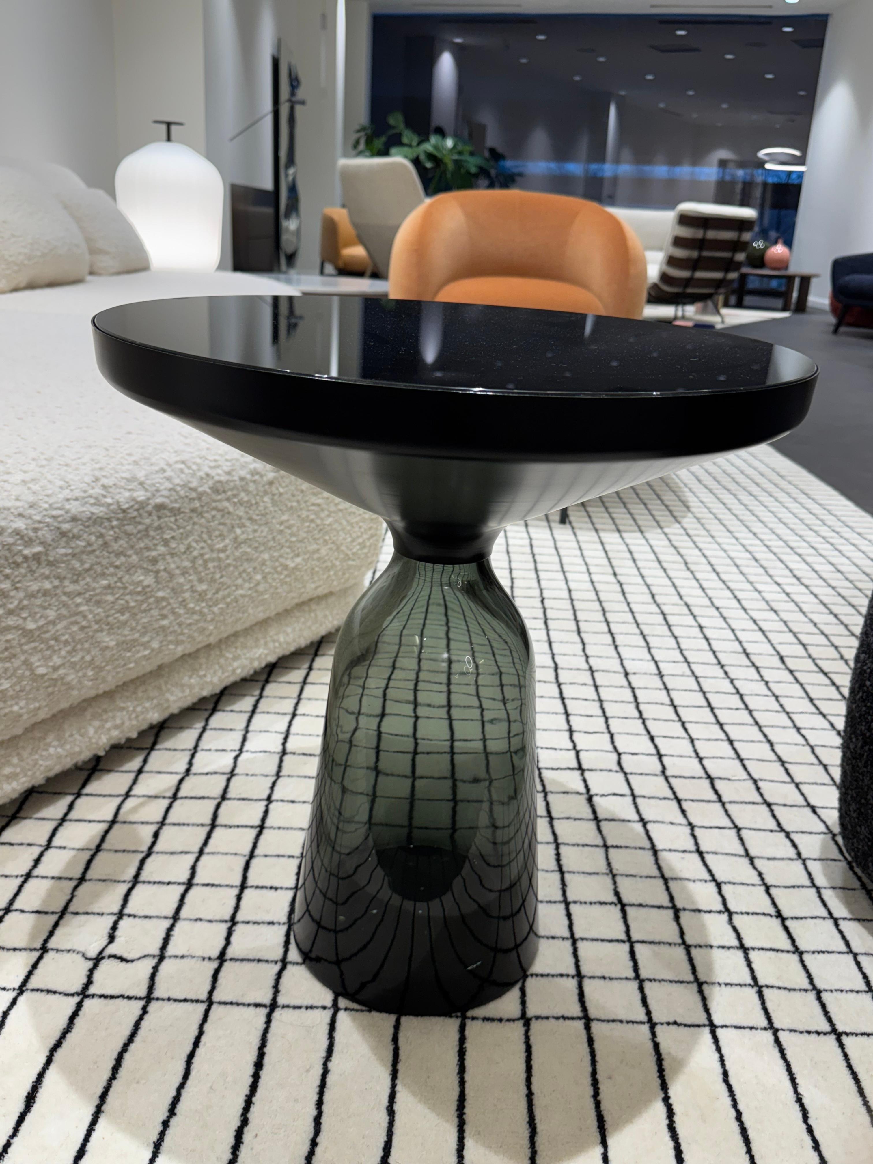 The bell table by Sebastian Herkner turns our perceptual habits on their head, using the lightweight, fragile material of glass as base for a metal top that seems to float above it. Hand blown in the traditional manner using a wooden mold, the