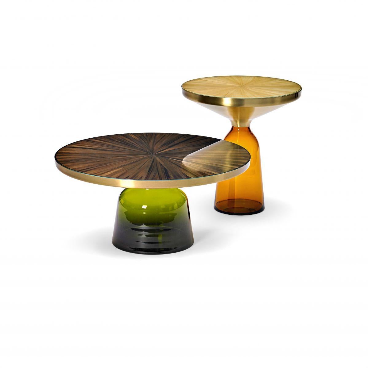Table d'appoint et table basse. Plateau de table avec marqueterie de paille encadrée de verre dans divers...
versions.

La table Bell de Sebastian Herkner bouleverse nos habitudes de perception en utilisant le matériau léger et fragile qu'est le