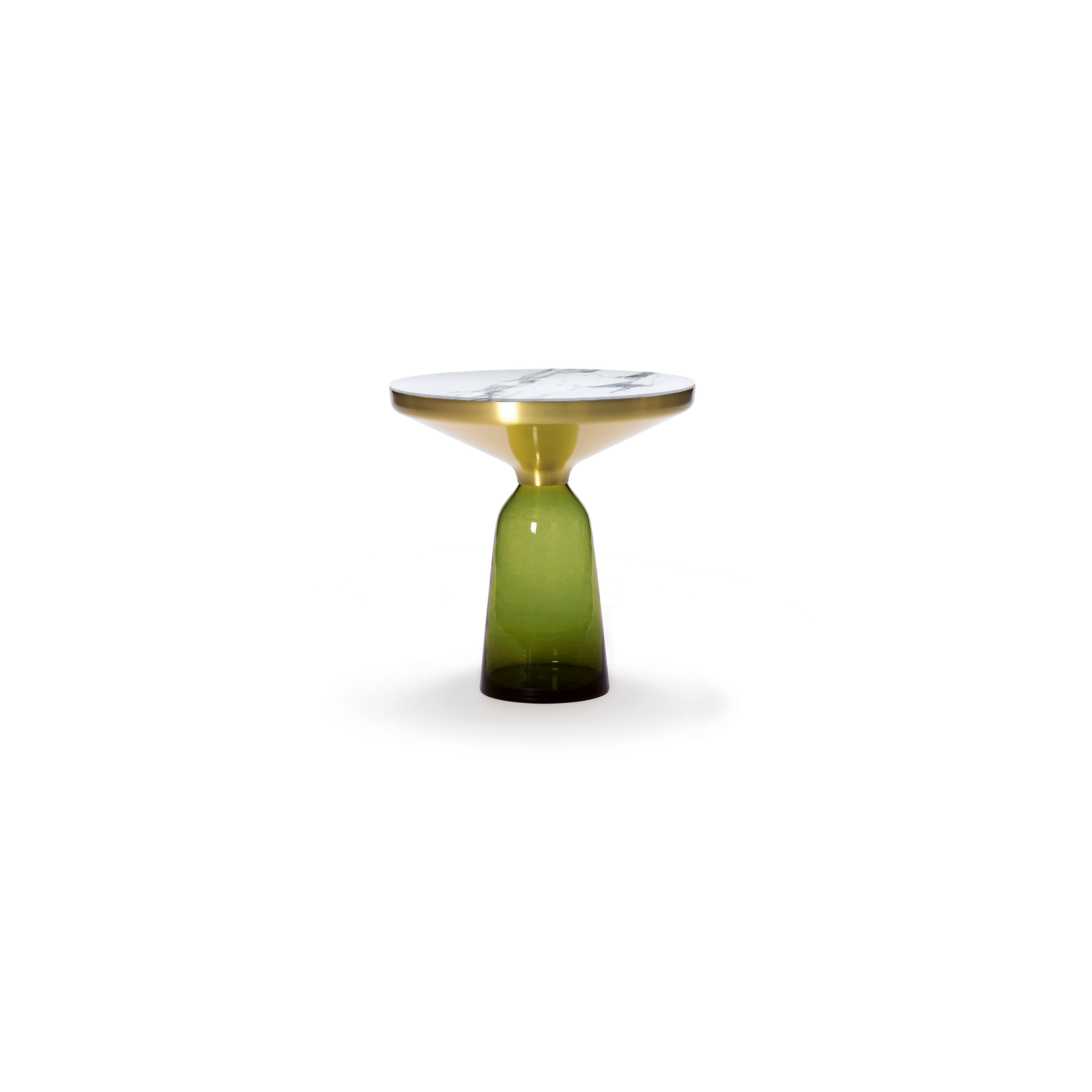 Un classique moderne en miniature : la table cloche de Sebastian Herkner bouleverse nos habitudes de perception en utilisant le matériau léger et fragile qu'est le verre comme base pour un plateau métallique qui semble flotter au-dessus. Soufflée à