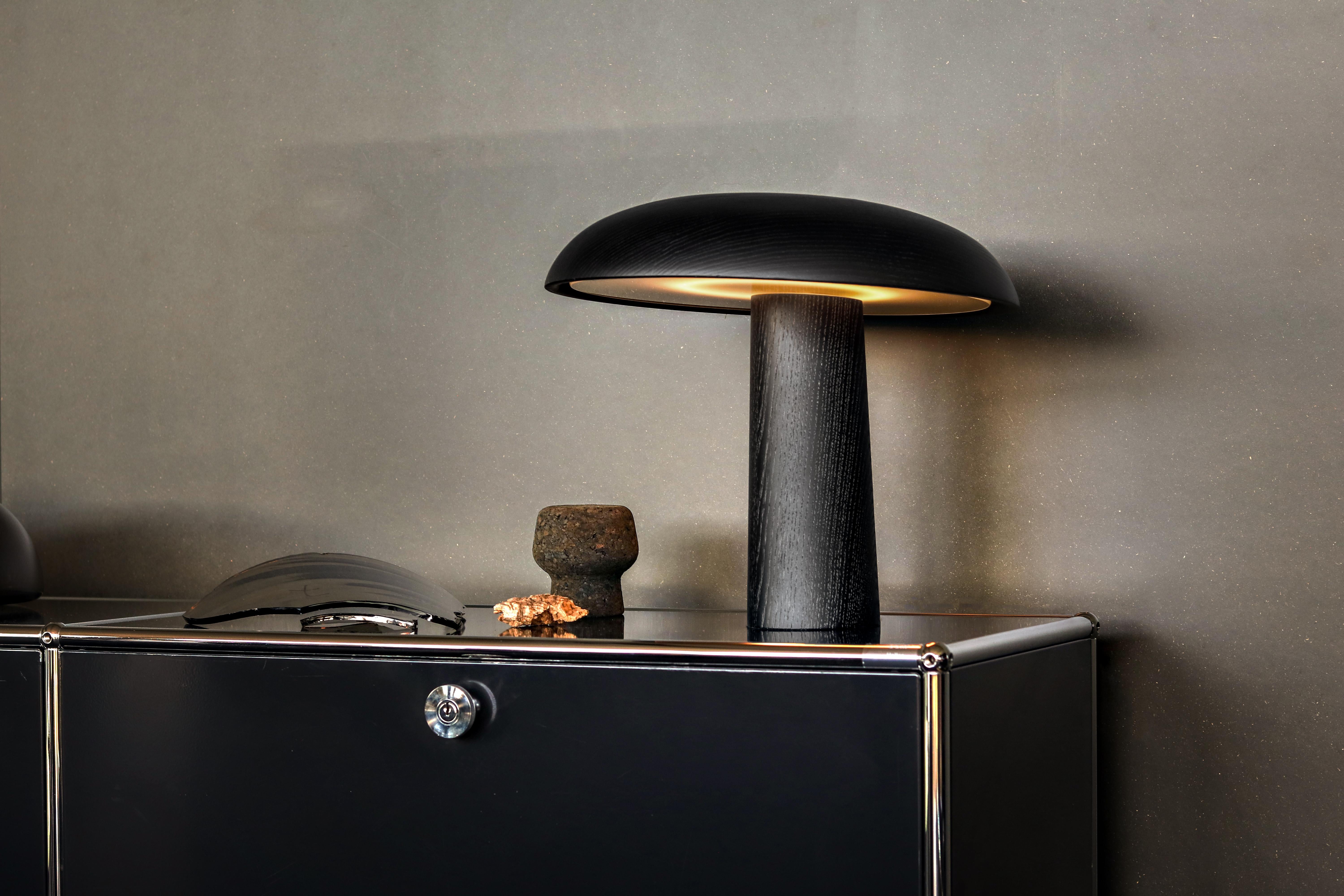 Table lamp. Base and shade solid ash, natural with clear varnish or black
lacquered, or solid walnut, natural, with clear varnish. Satinised glass diffuser
panel. Infinitely dimmable with memory function. Felt gliders in black. Cable
length 2 m.