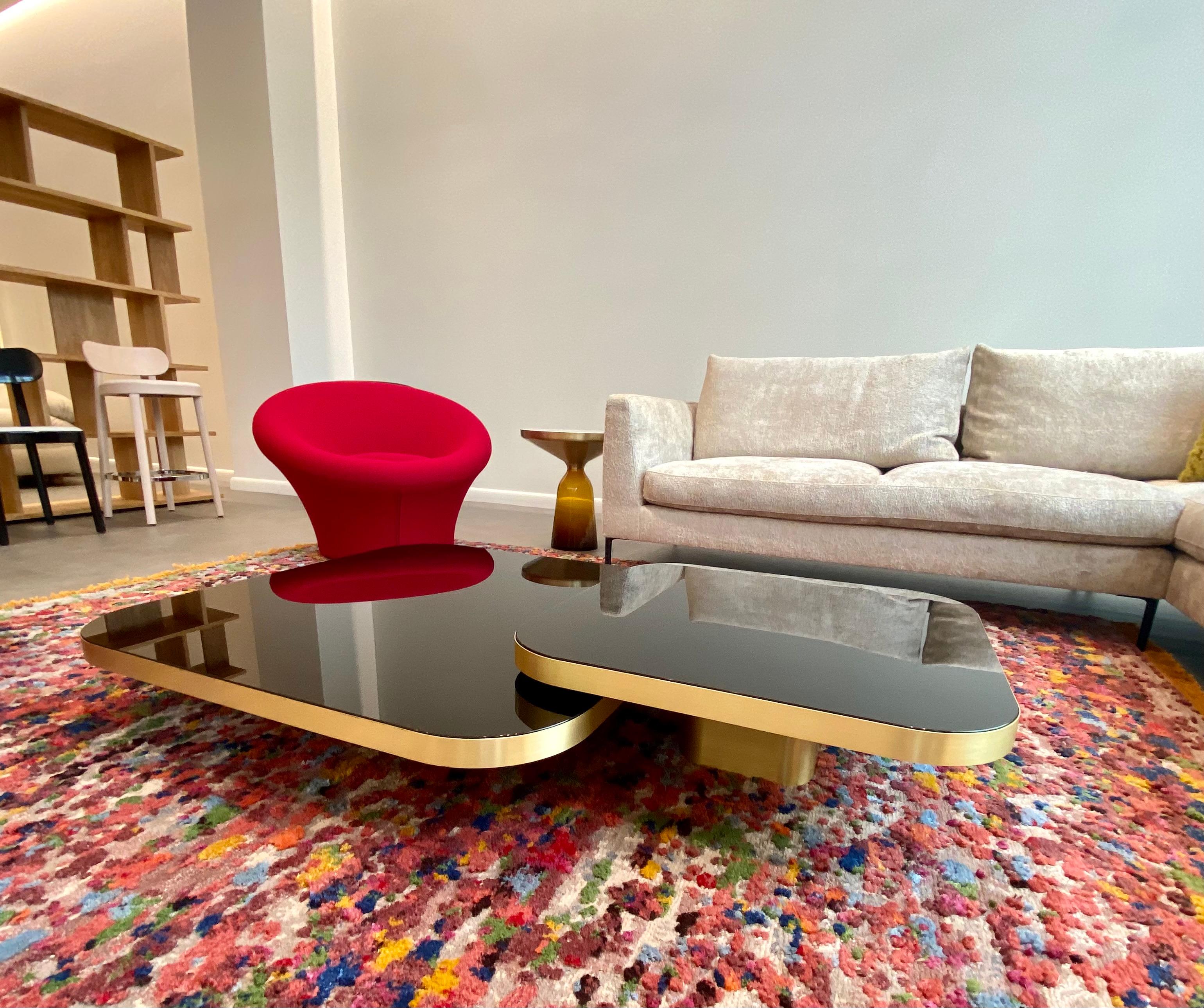 Bow #2 & 4
#2 size: 70x70x25cm
#4 size 100x100x19cm
Brass and glasstop black
Inspired by 1970s lines and designs, Brazilian Guilherme Torres presents a side table or coffee table of casual elegance. The metal-covered surface of the body also