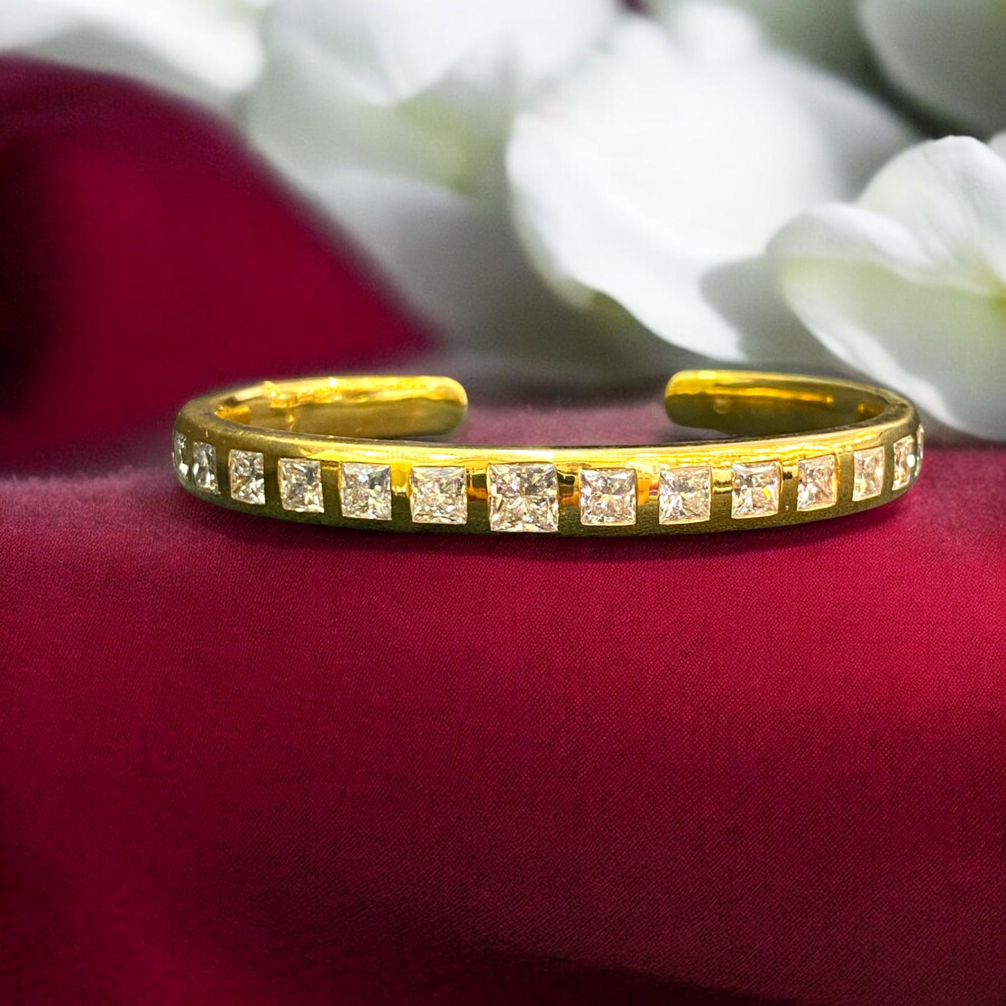 This exquisite unisex bracelet boasts a total carat weight of 10.10 Cts, with a stunning princess shape diamond at the center and 0.50 Cts diamonds on each side. The bracelet is made of 14K yellow gold and features a flush setting style, with a cuff
