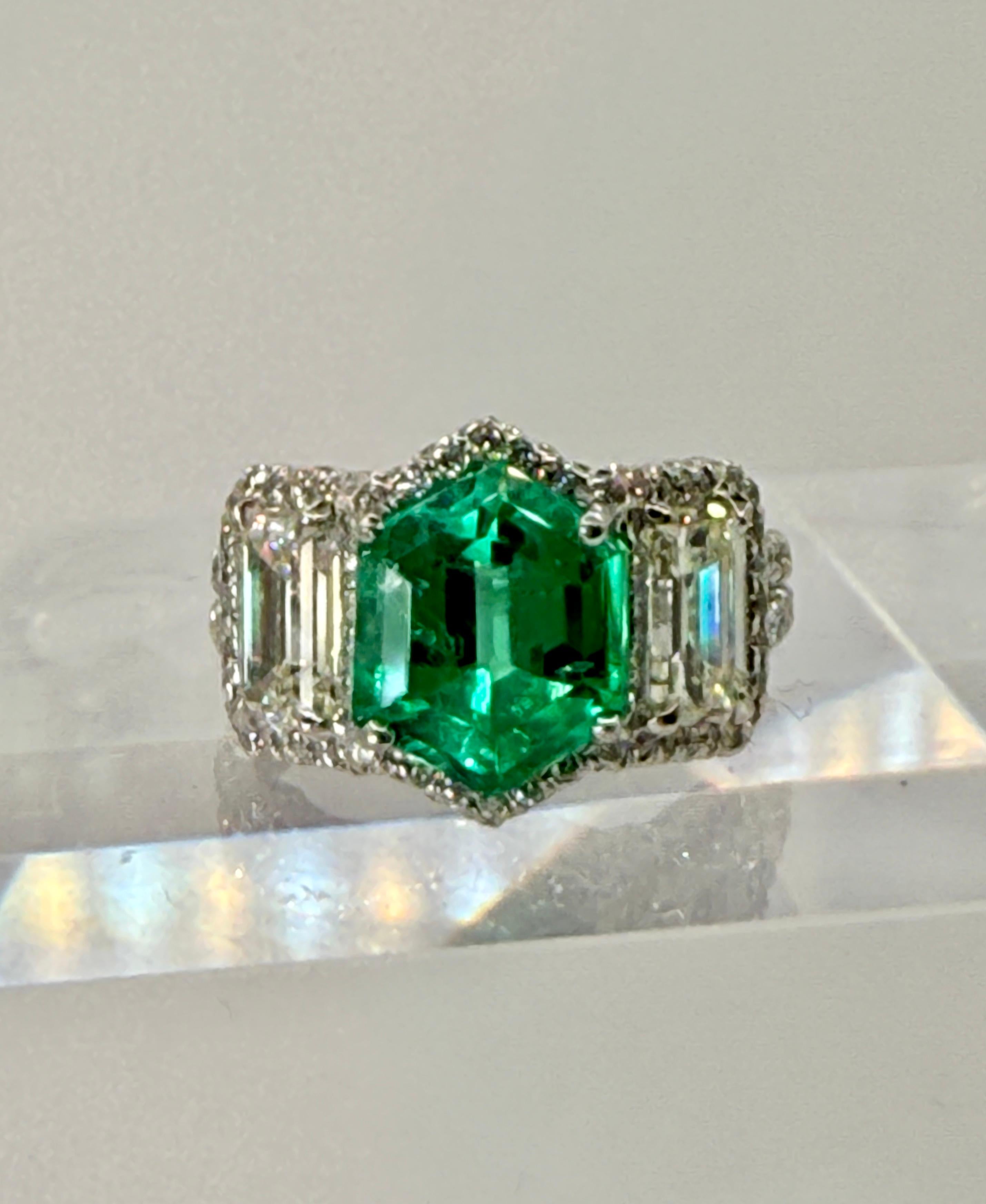 Emerald is a Unique Hexagonal Cut of Top Crystal Material.  Accompanied by an AGL Certificate Stating Colombian Origin with Minor Clarity Enhancement.  

The Emerald is Flanked by 2 Emerald Cut Diamonds Having a Total Weight of 2.02 Carat.  Average