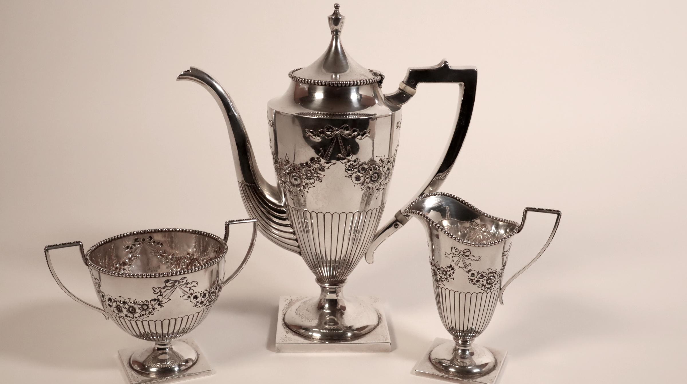 Store closing March 31. A classy American Edwardian period sterling silver three piece coffee service comprising coffeepot, cream jug and twin handled sugar bowl, each of pedestal form with angular handles, beaded rim detail and decorated with