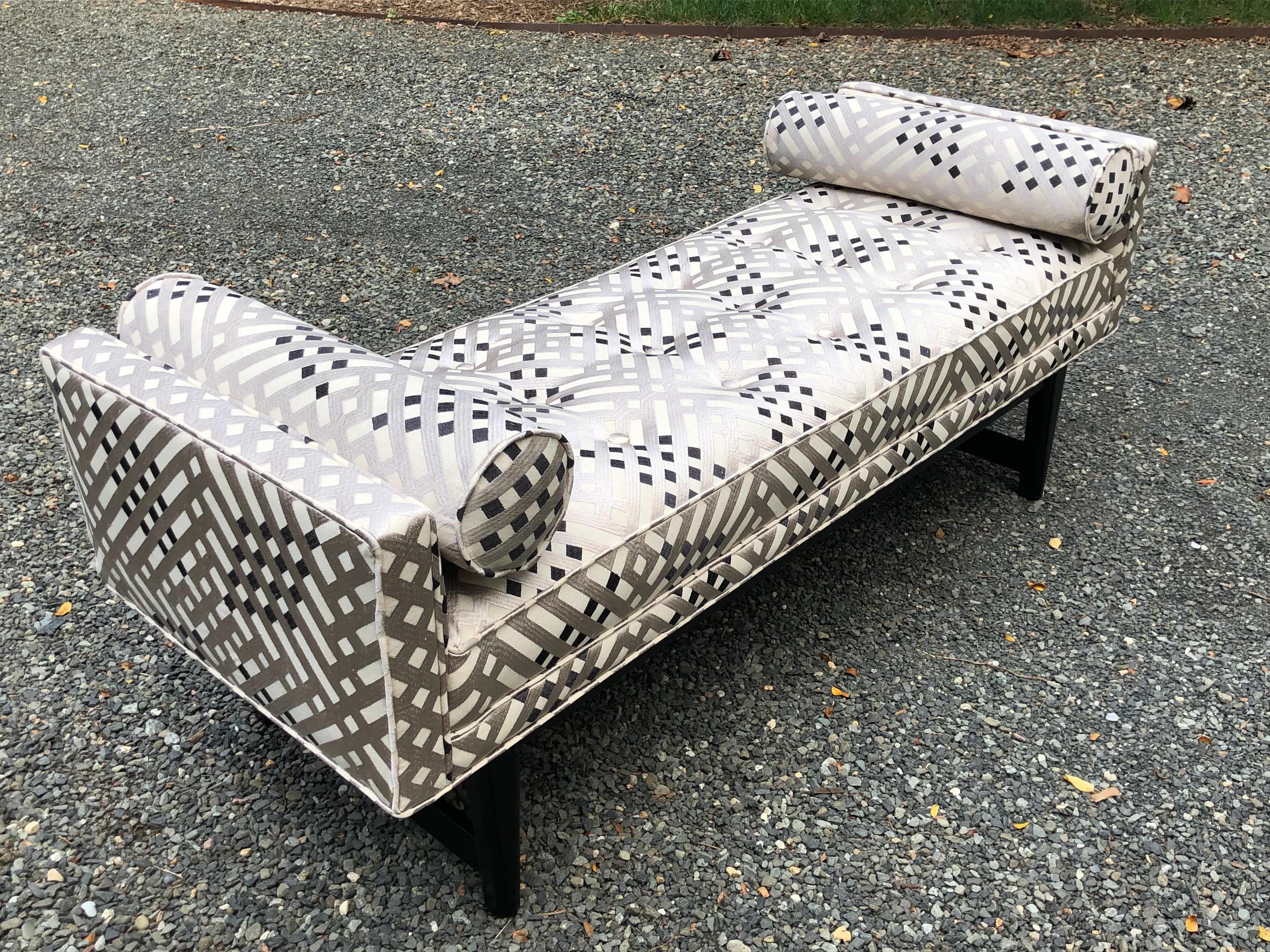 Classy Mid-Century Modern settee bench newly upholstered in a silvery grey, black and white stylized lattice fabric. Tufted seat, straight arms and ebonized legs. Rolled accent cushions.
