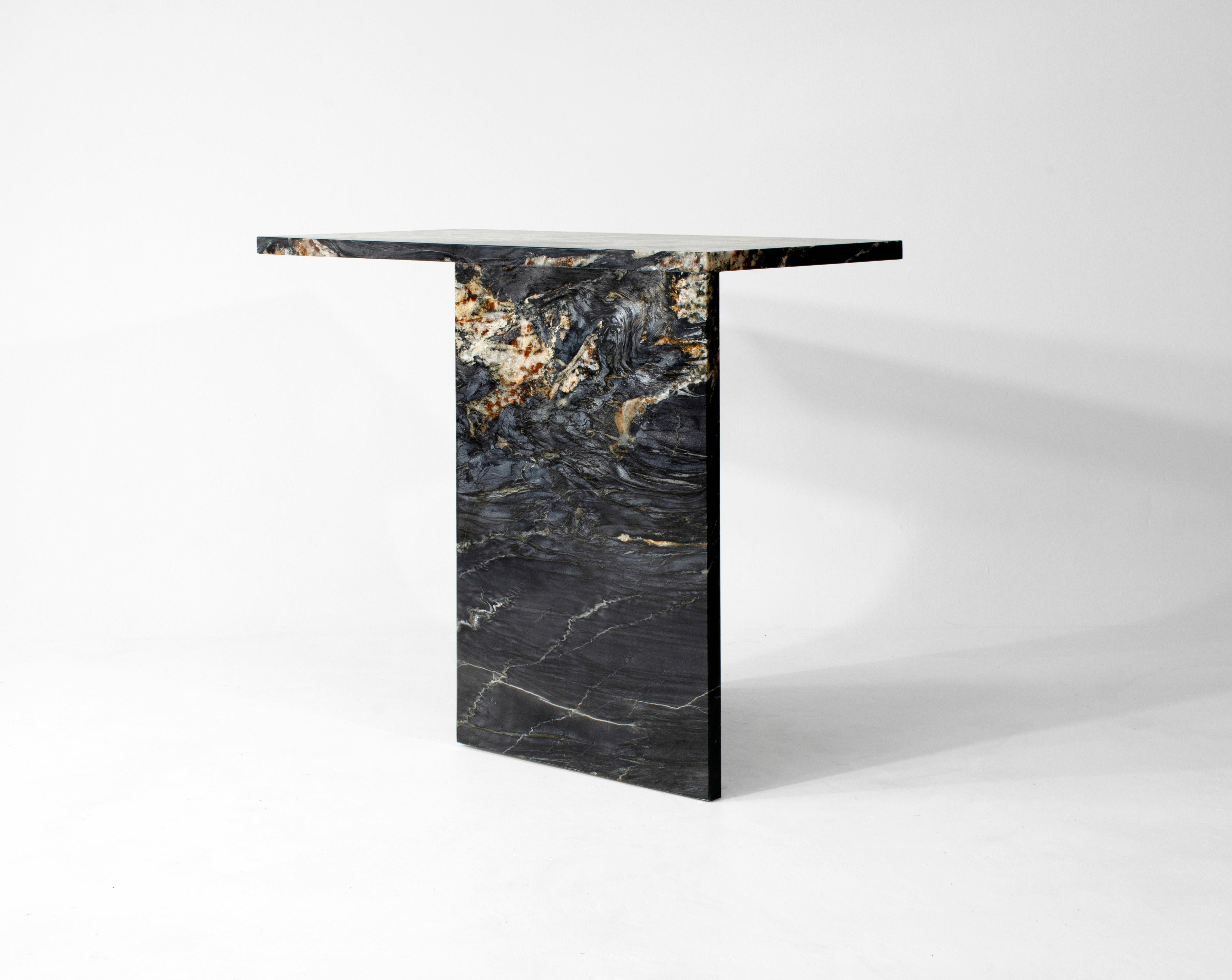 A console which has four distinct elevations. The strength and weight of the piece creates a sense of stability while simultaneously appearing as if it may fall over at any minute. The asymmetrical, triangular base in combination with the