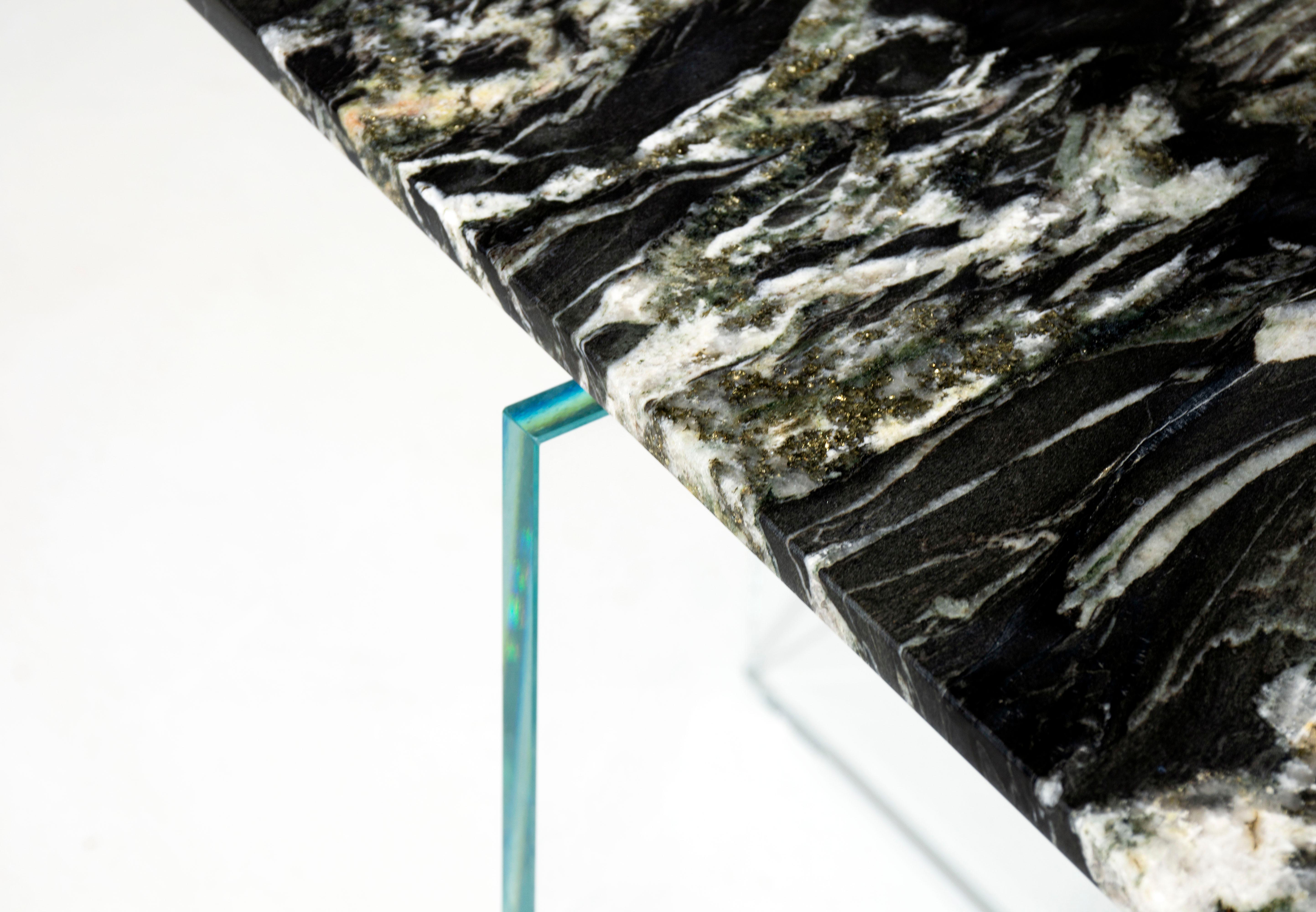 A simple table with a subtle gesture where the marble top appears to float above the glass base. Achieved by hand shaping each piece of stone, the thin edge disguises the actual thickness of marble while achieving a sense of disconnect from the