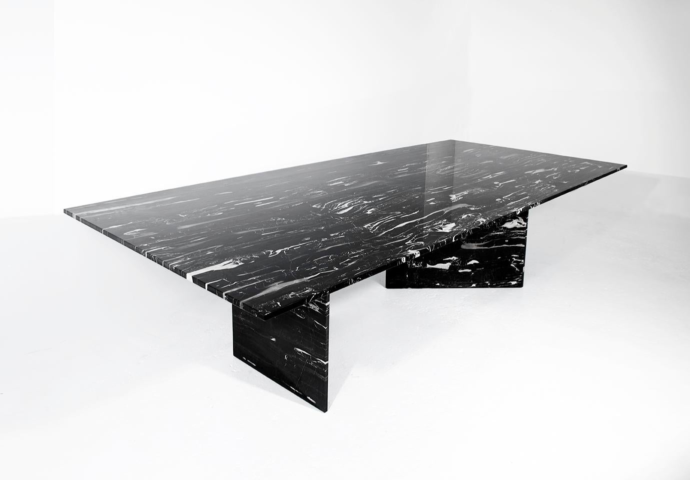 Cette table combine la beauté du marbre avec un brin de suspense. Les pieds triangulaires créent plusieurs points de vue différents où la table donne l'impression d'être soutenue par les plus fines lames de marbre, ce qui suscite un sentiment