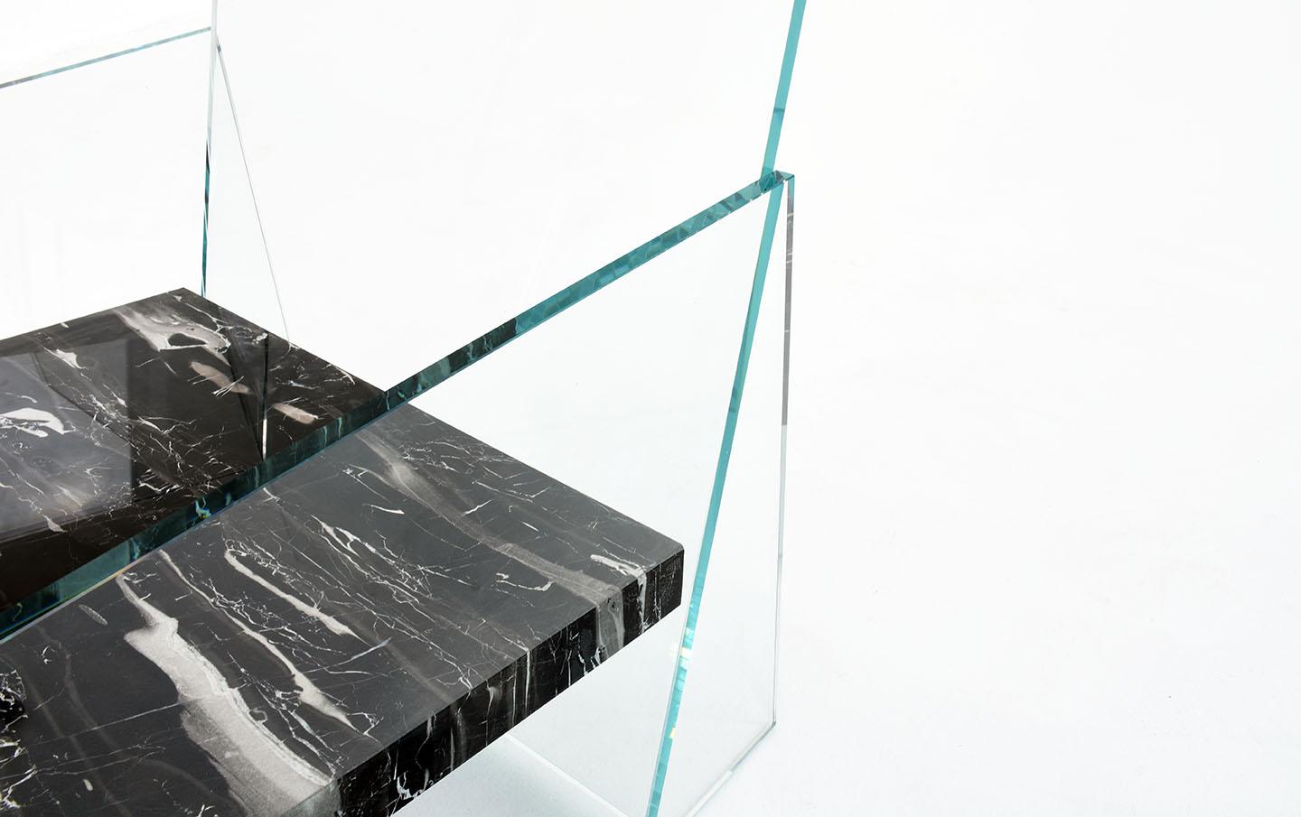 A floating slab of marble suspended between panes of clear or tinted glass with no hidden hardware or mechanical fastenings adds a level of tension to the everyday act of sitting down where one has to force themselves to suspend their disbelief and