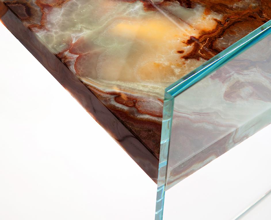 A floating slab of marble suspended between panes of clear or tinted glass with no hidden hardware or mechanical fastenings adds a level of tension to the everyday act of sitting down where one has to force themselves to suspend their disbelief and