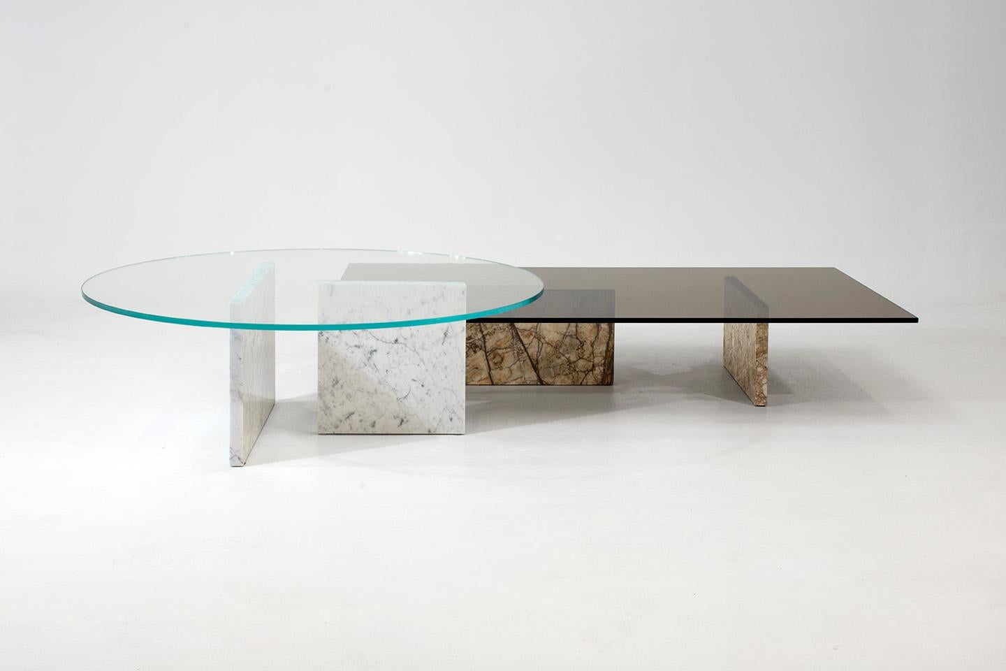 The two freestanding marble legs, seemingly precariously balanced beneath the floating plane of glass create an almost magical feel for this coffee table as there seems to be no logical explanation for why it does not collapse. Available in both