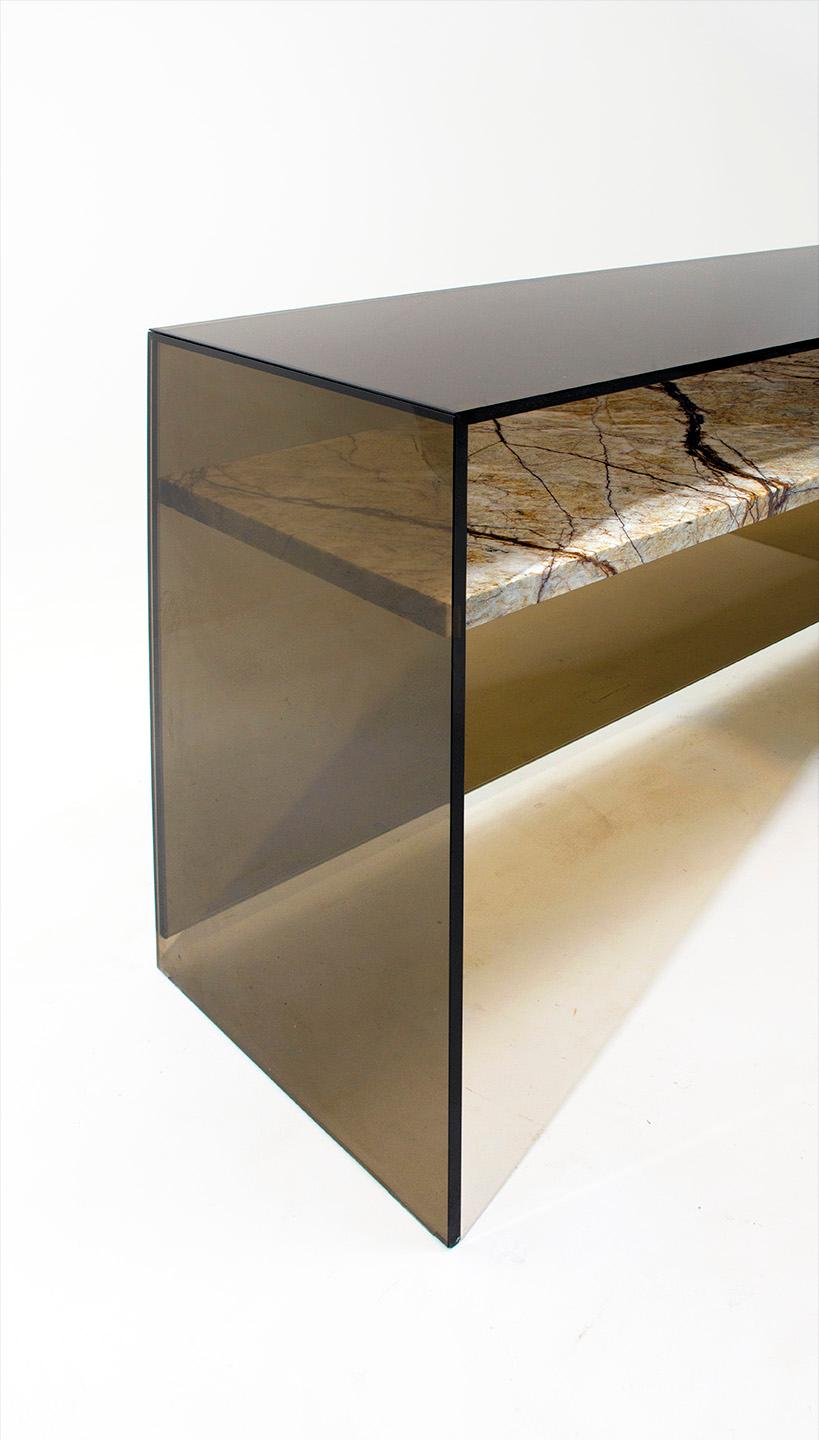 The floating shelf of marble punctuates this Minimalist console with a touch of the unreal. Without the use of any concealed hardware the invisible joint between the marble and the glass creates an effect that is both striking yet elegant and