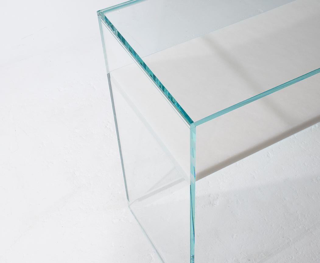 The floating shelf of marble punctuates this Minimalist console with a touch of the unreal. Without the use of any concealed hardware the invisible joint between the marble and the glass creates an effect that is both striking yet elegant and