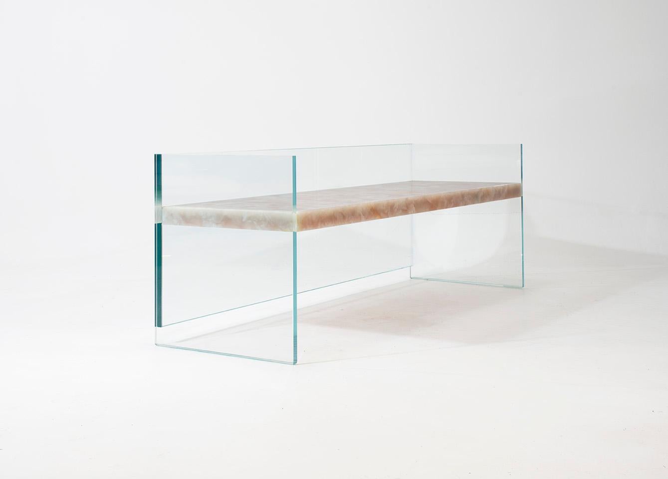 A handcrafted slab of marble or onyx is suspended between 3 panes of glass to create this remarkable bench which emphasizes both the beauty of the stone and the delicate yet deceptive strength of the transparent legs. Every slab is structured by